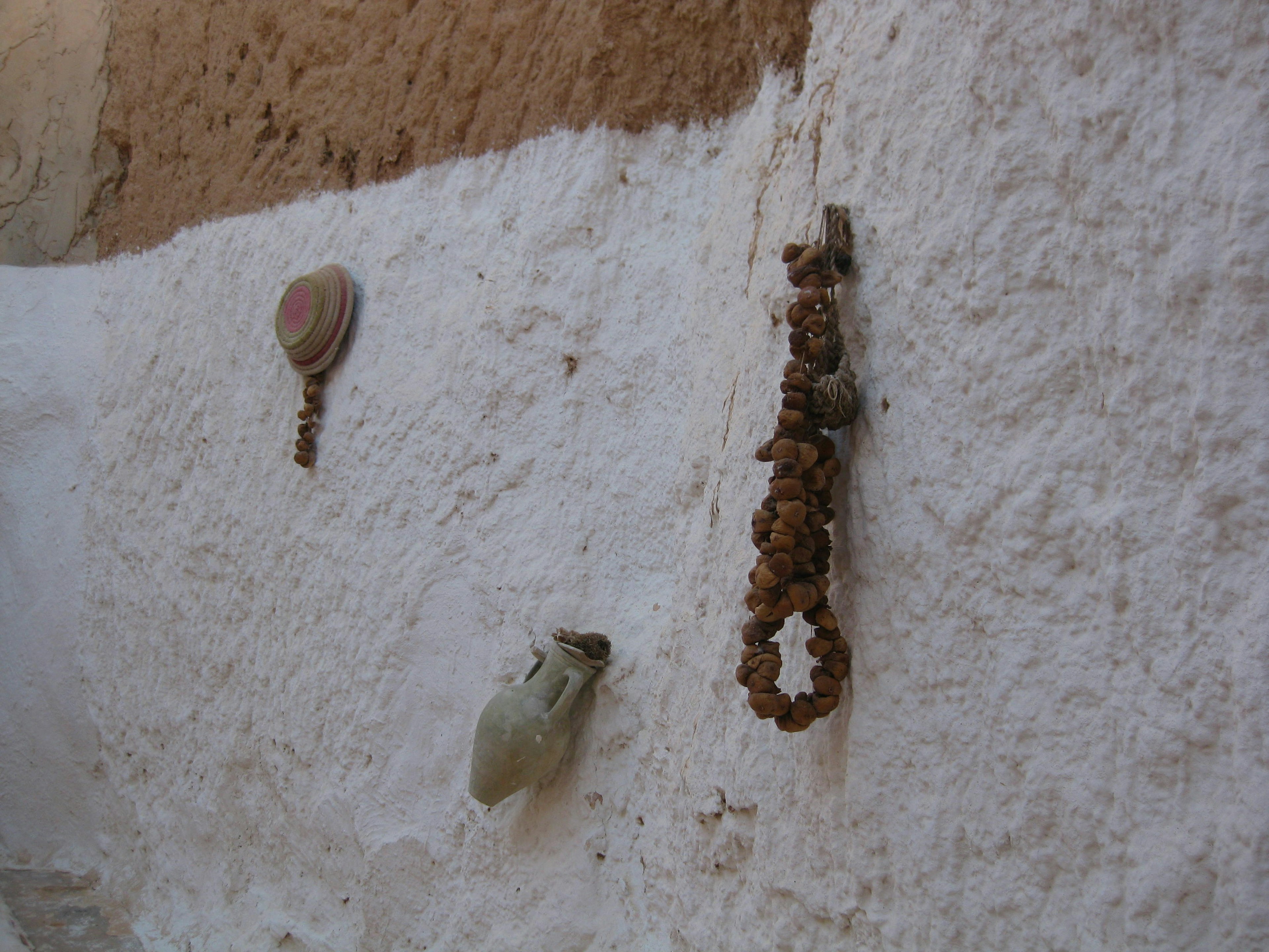 Exhibición de conchas y adornos en una pared blanca