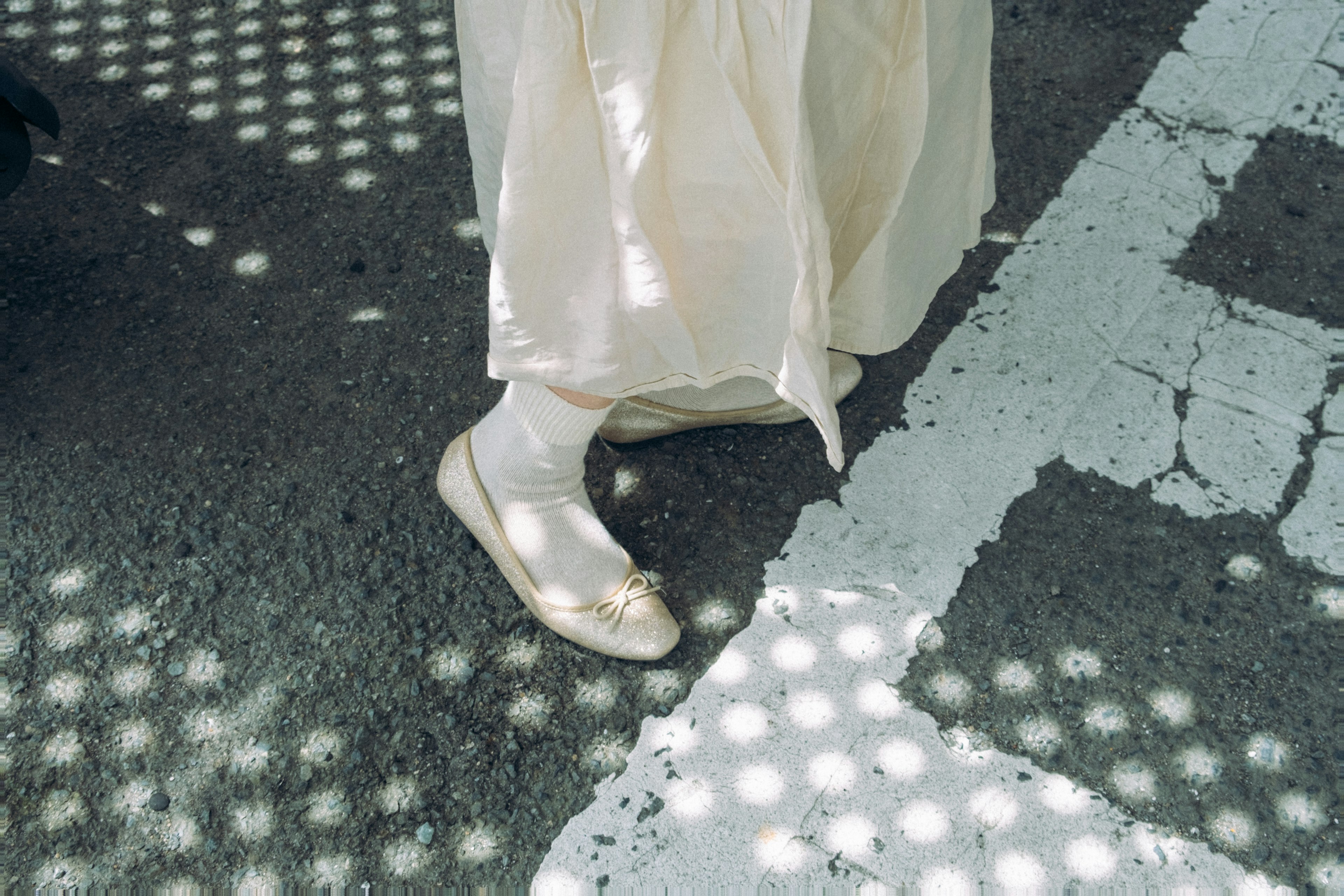 Footwear featuring a flat shoe with a light dress in a patterned environment