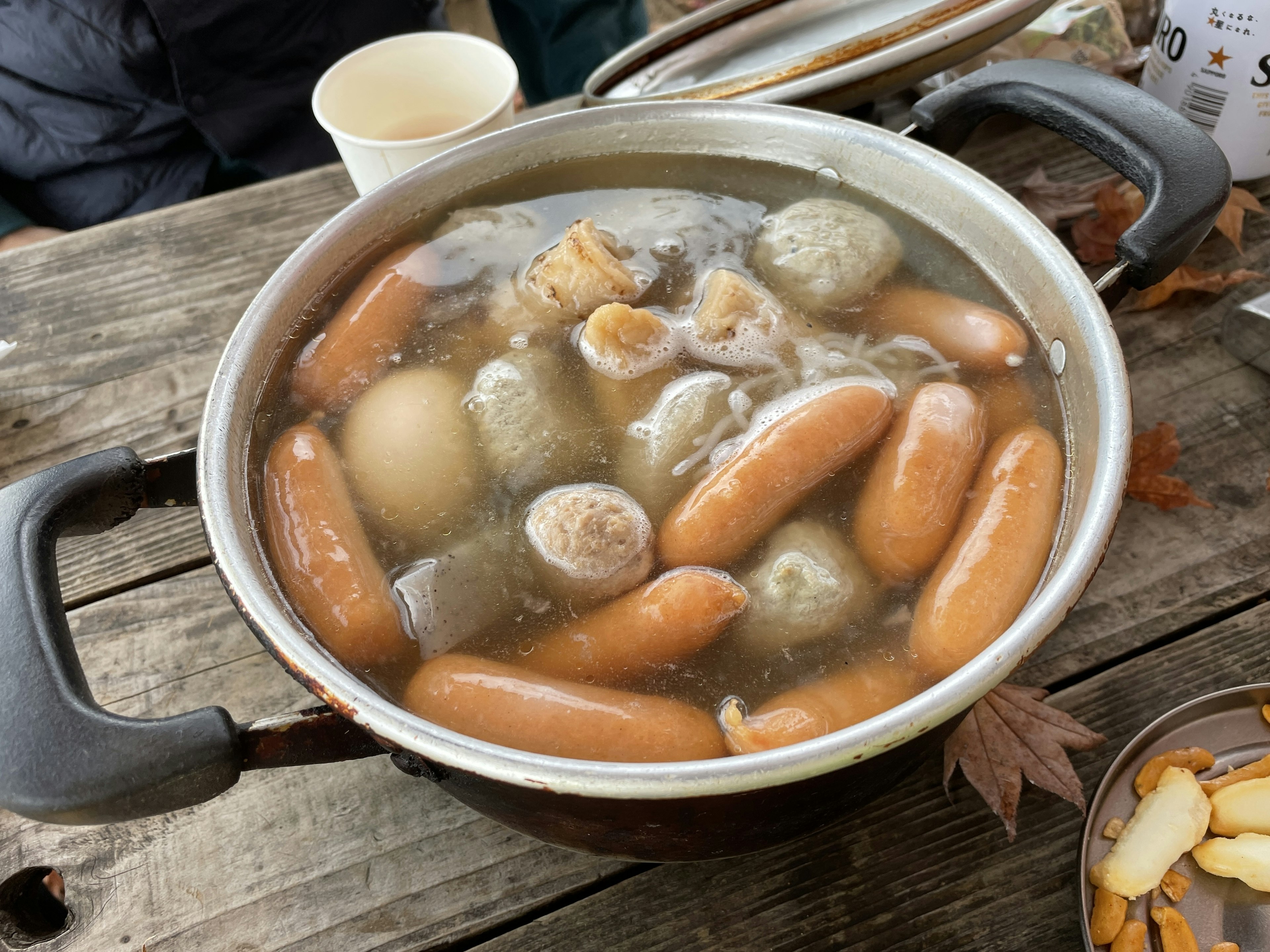 Una pentola piena di salsicce, gnocchi e uova in brodo