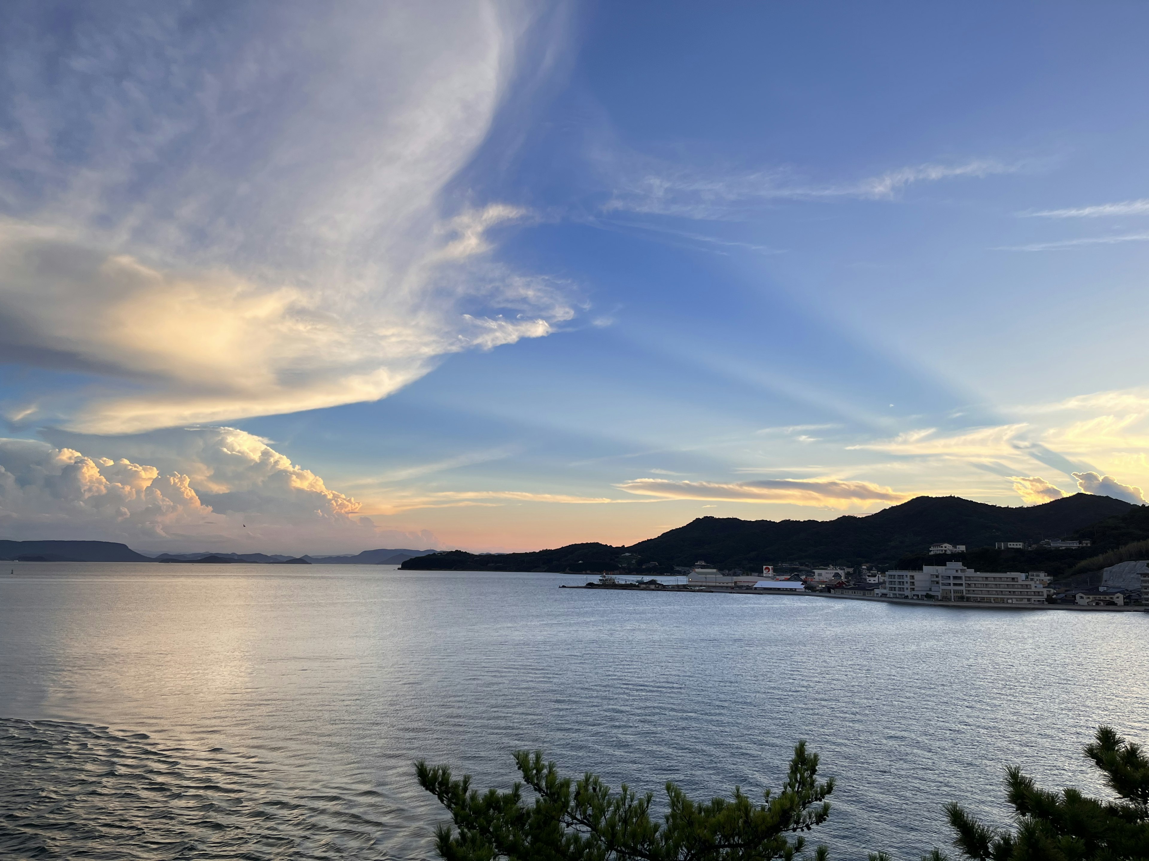 美しい海の景色と青い空の風景 夕暮れの雲と山々のシルエット