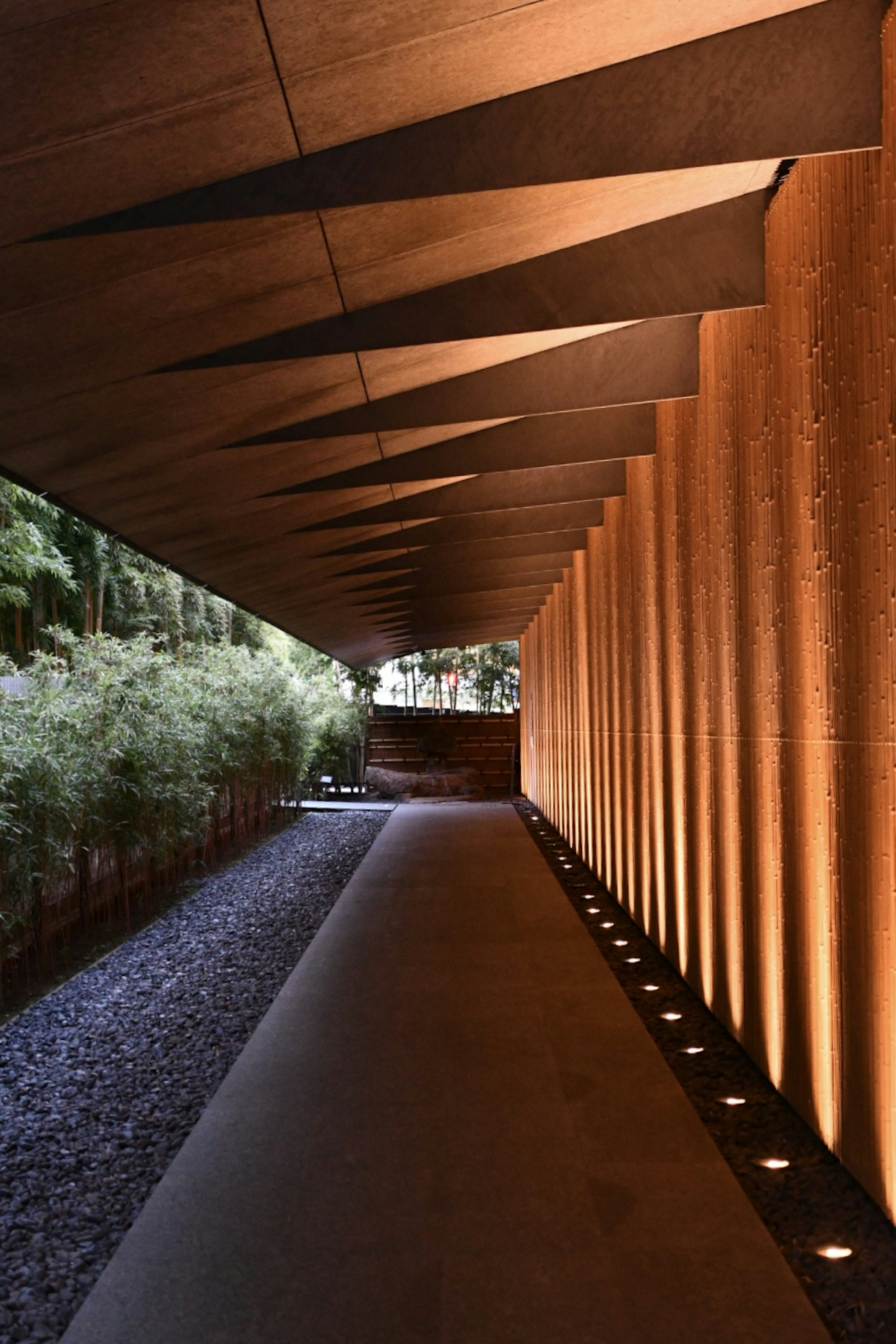 Pasillo elegante con iluminación cálida y paredes de madera con vegetación visible