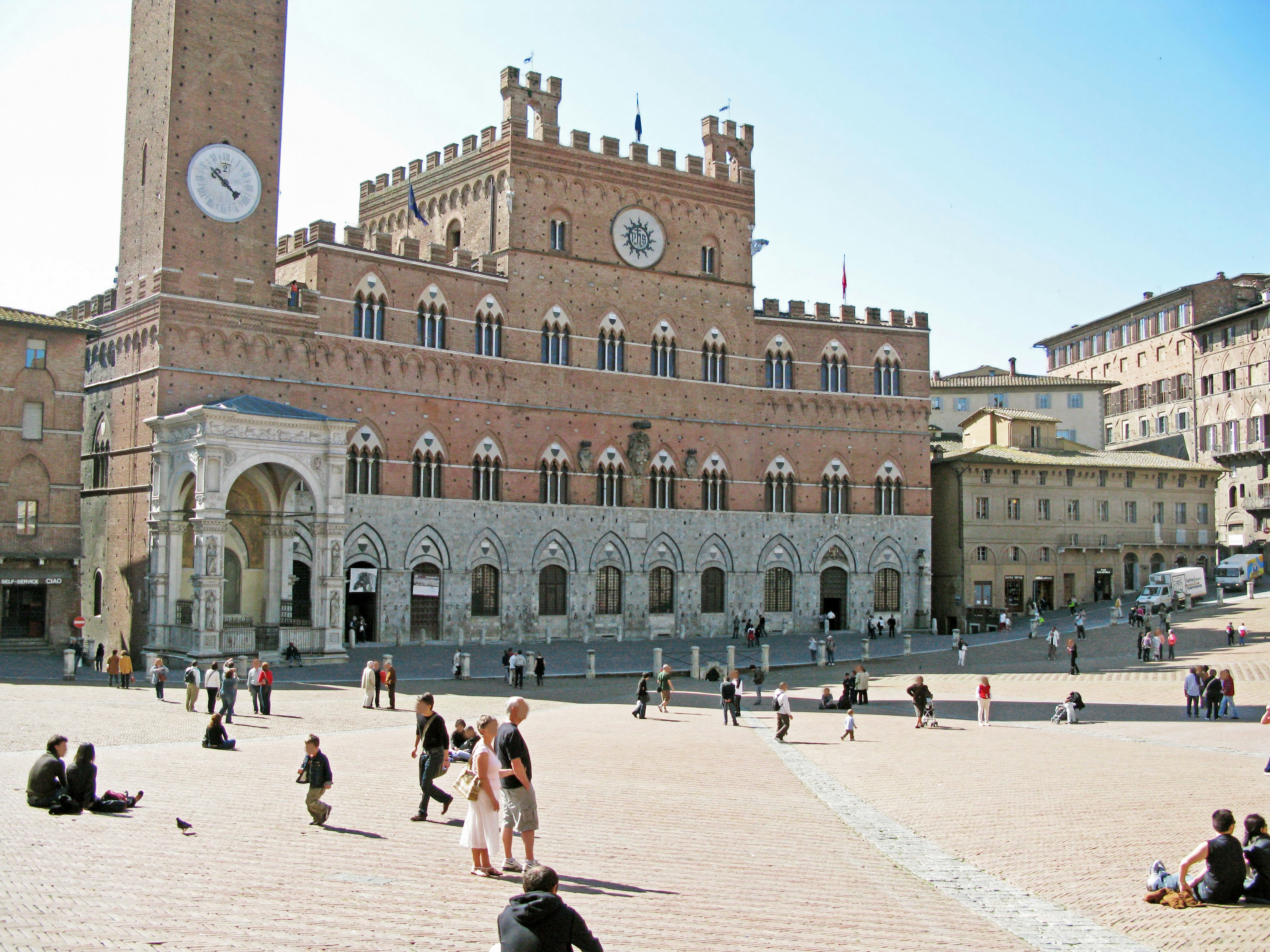 A scenic view of a square with historical buildings under a clear blue sky