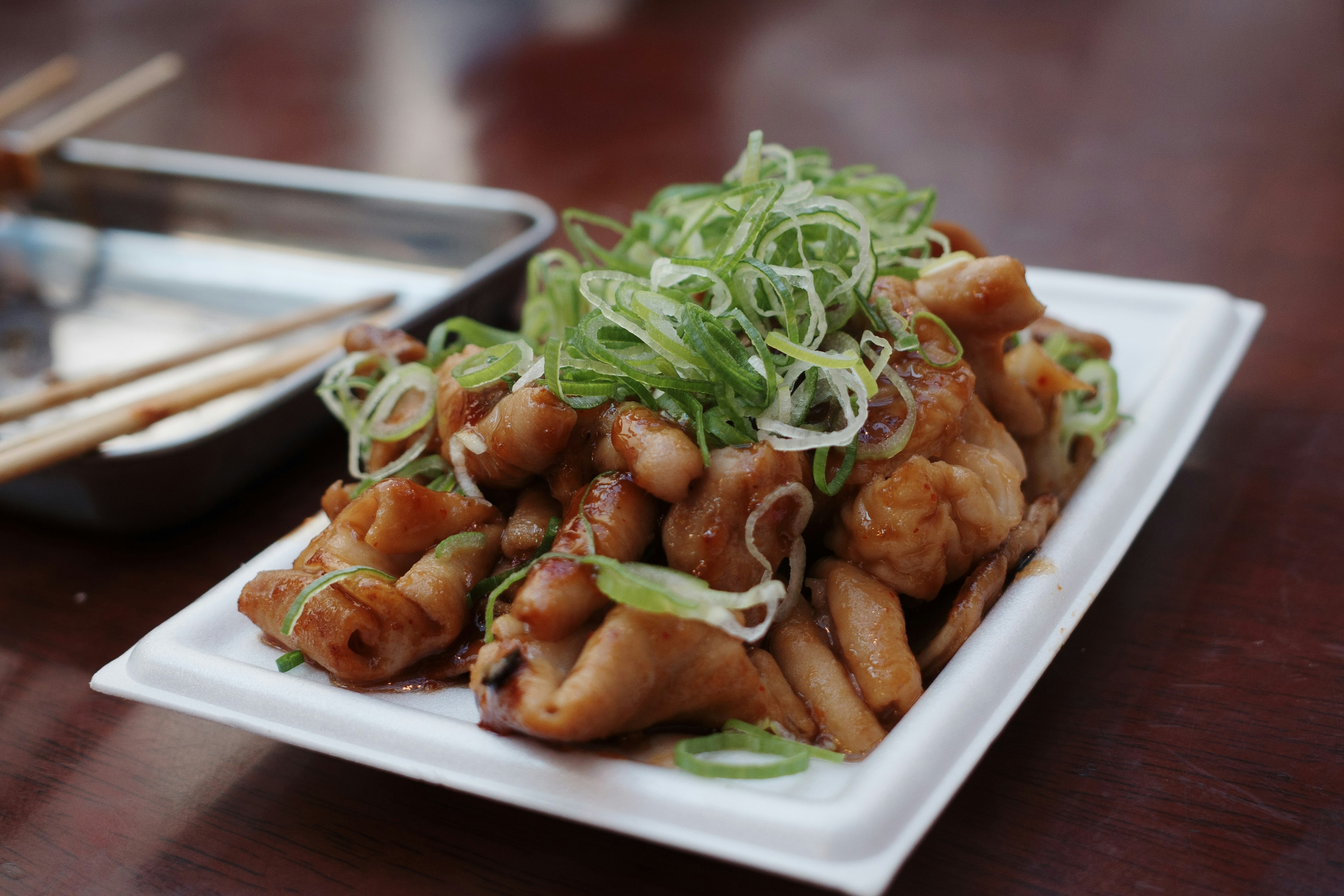 Un plat de poulet savoureux garni d'oignons verts tranchés