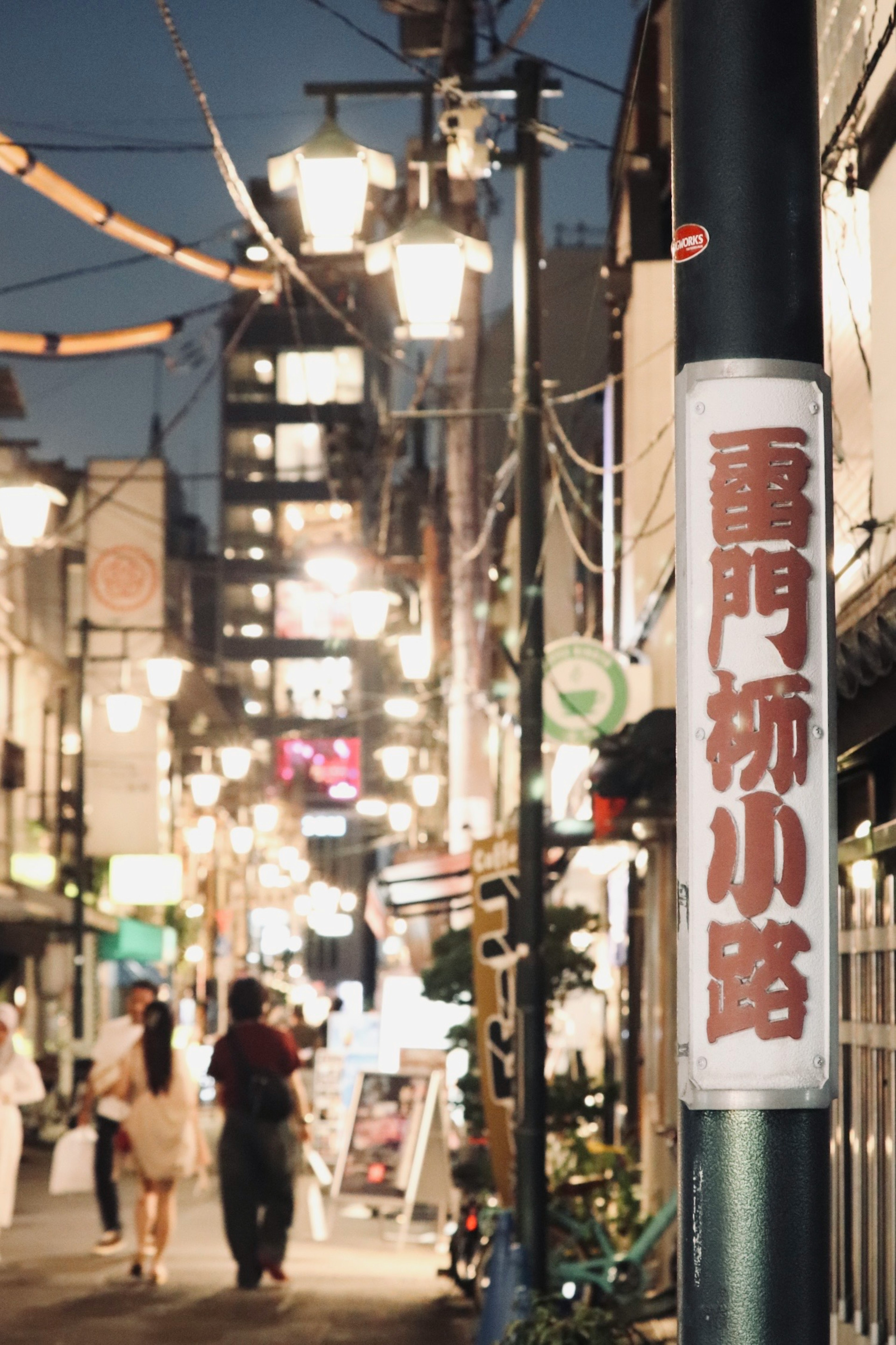 夜の街並みの小道にある看板と照明