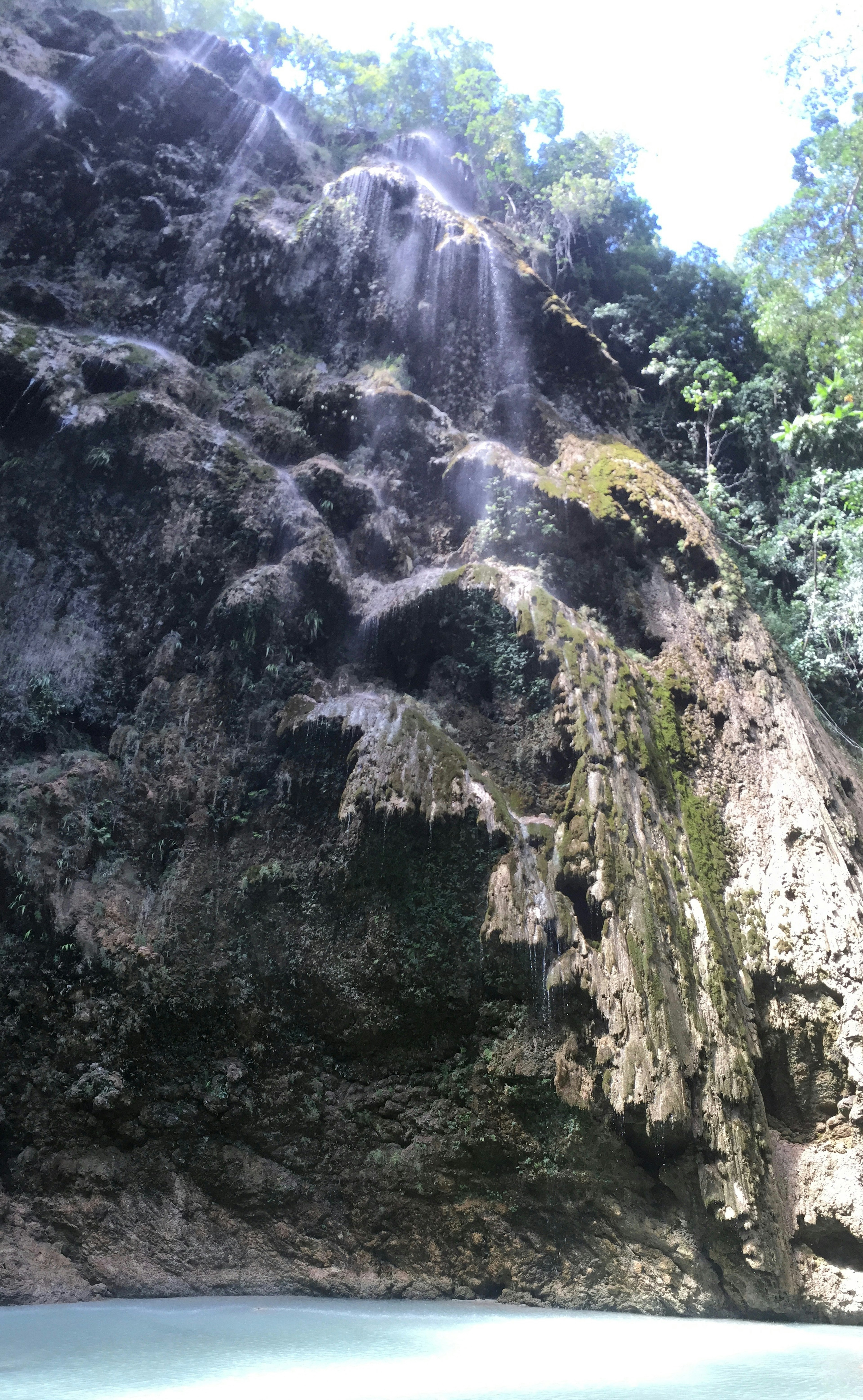 Hermosa cascada que cae de un acantilado rocoso con agua turquesa