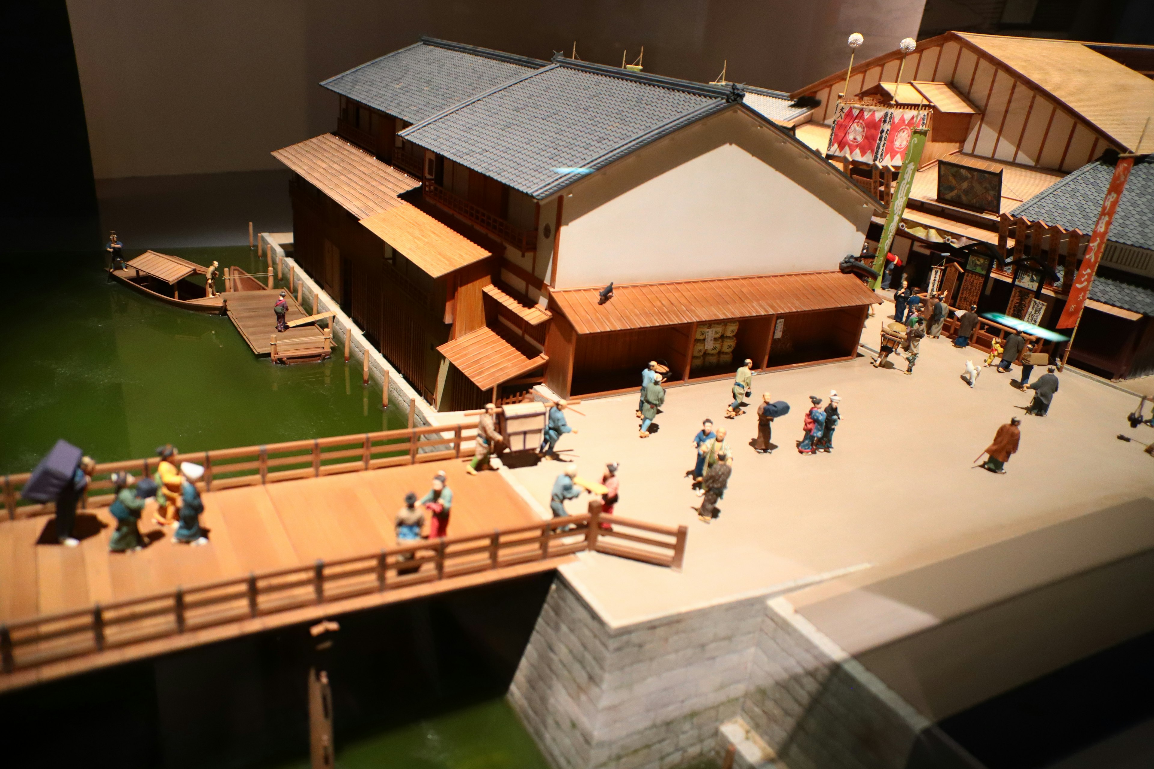 Traditional Japanese town model with people crossing a bridge