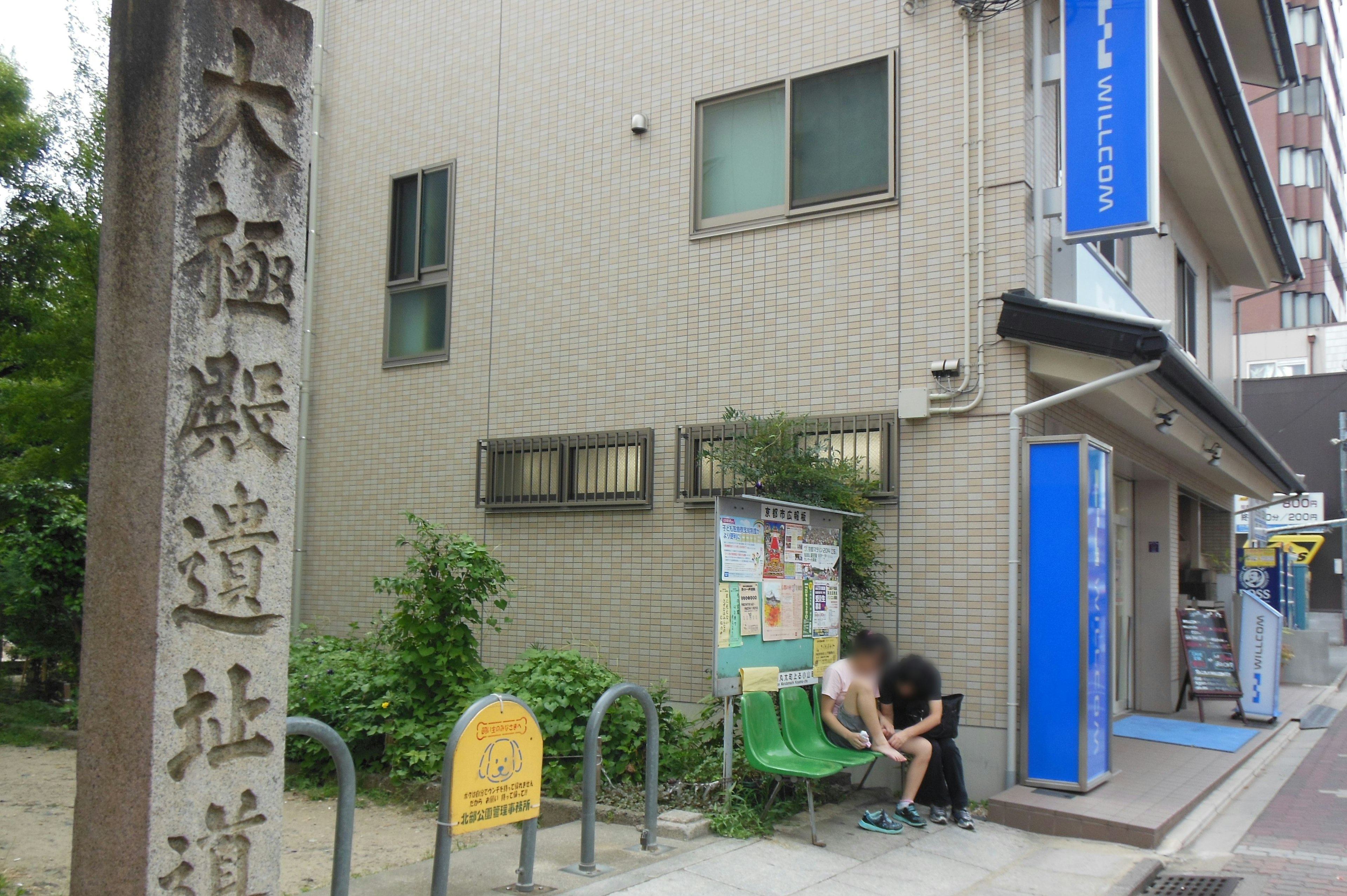 大極殿道社の看板がある街角の風景ベンチに座る二人