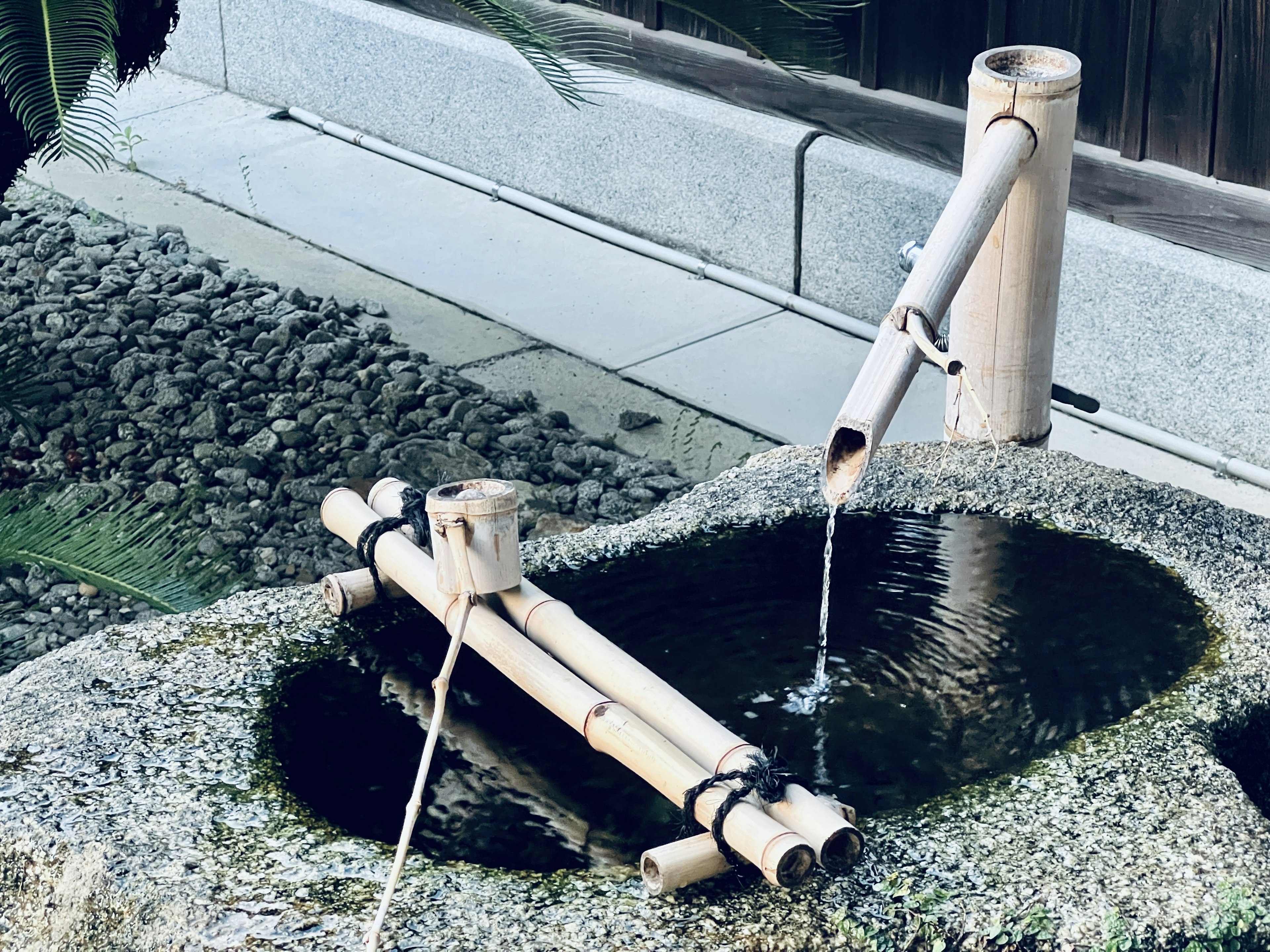 Un bassin en pierre avec un écoulement d'eau en bambou