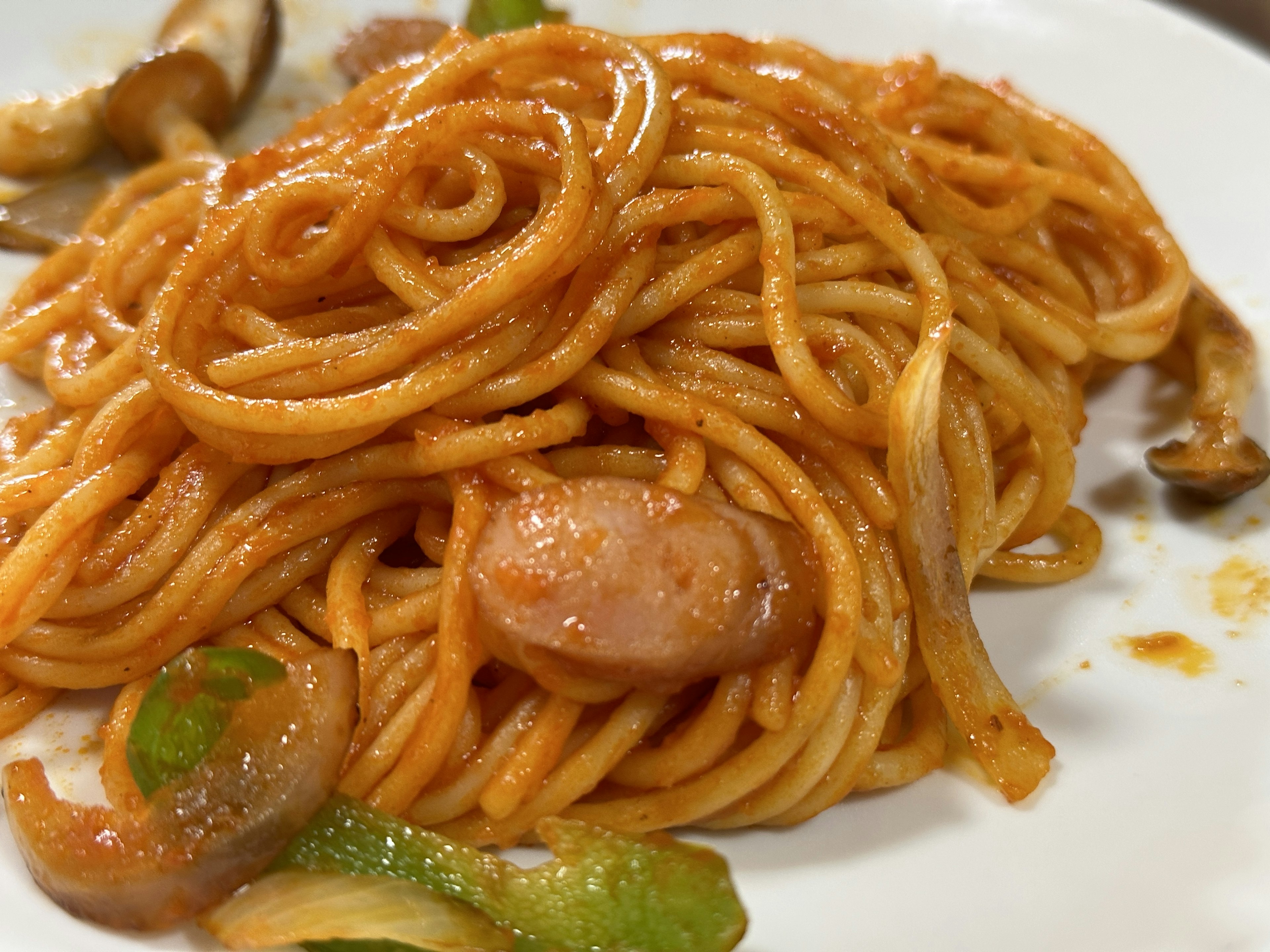 Plate of spaghetti topped with shrimp and green bell peppers