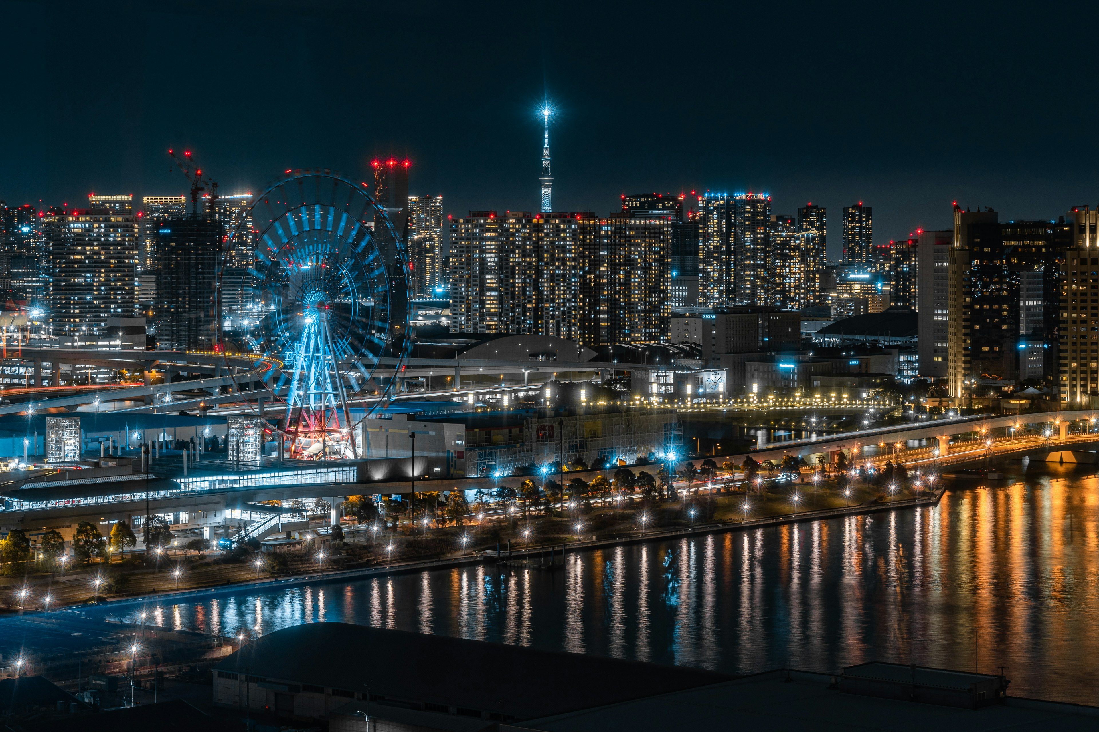 Night view of Tokyo's skyline featuring skyscrapers and a vibrant ferris wheel