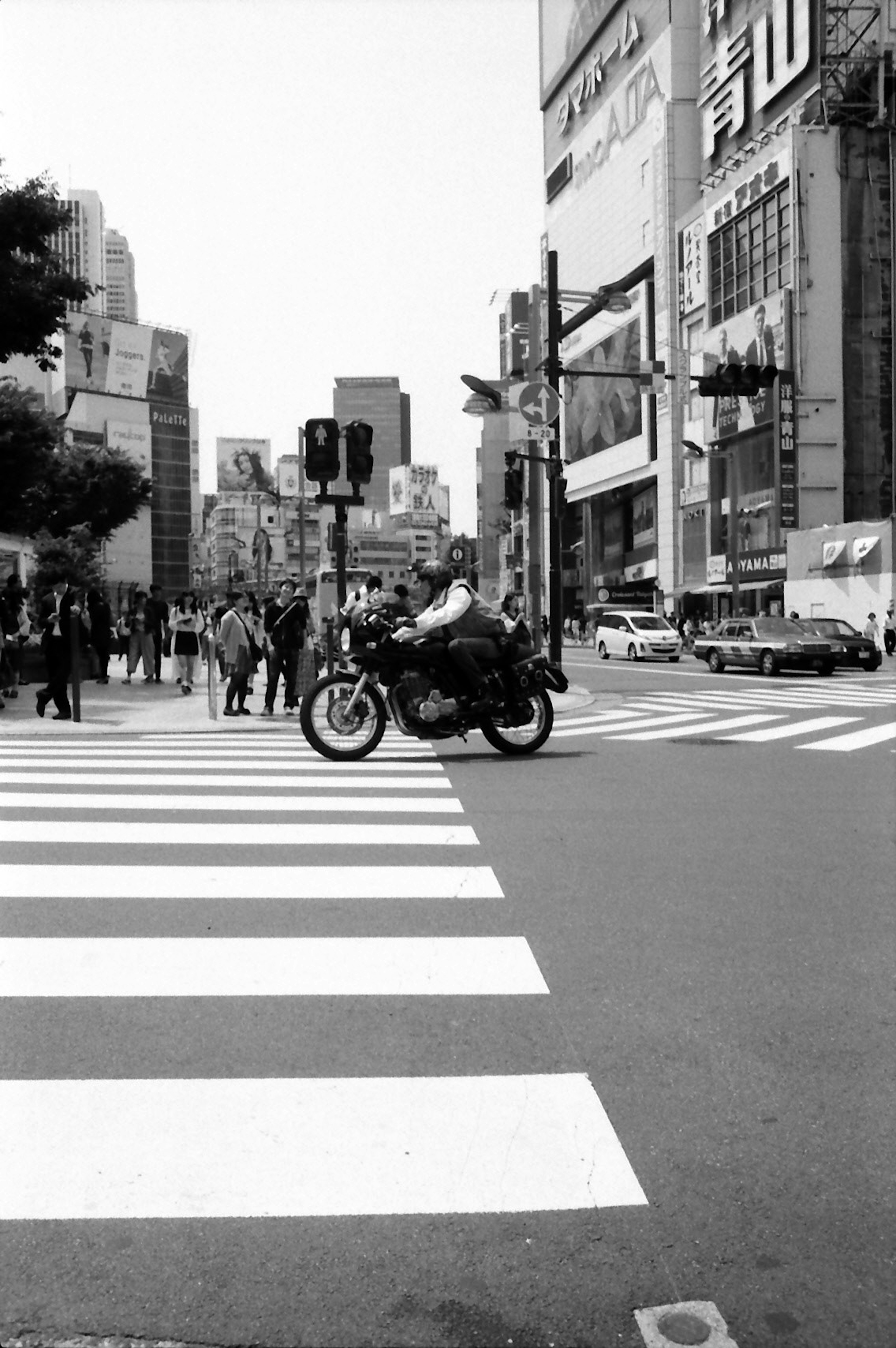 ทางแยกในเมืองสีขาวดำที่มีมอเตอร์ไซค์ข้าม