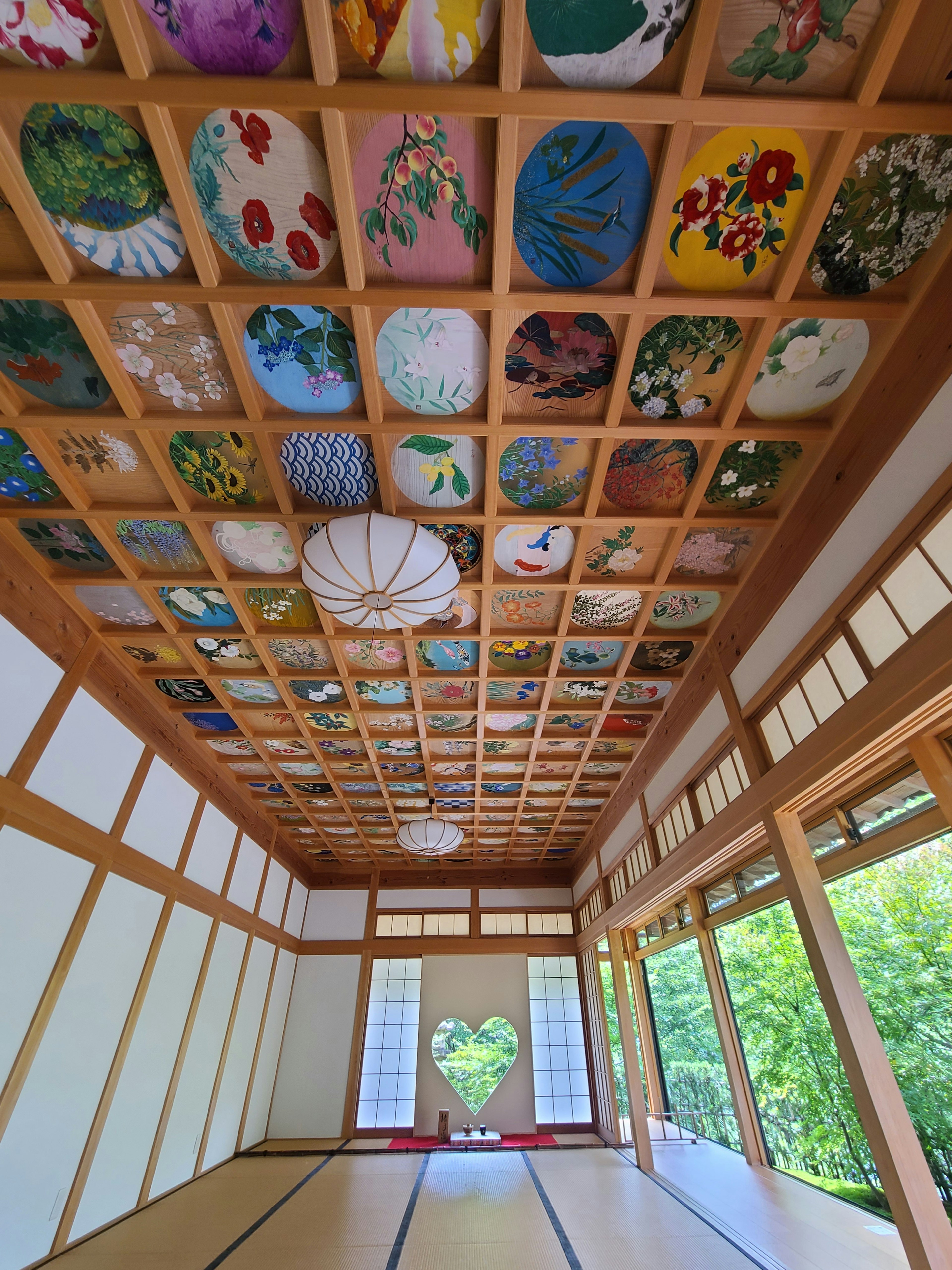 Interior of a Japanese room with a wooden ceiling adorned with colorful paintings