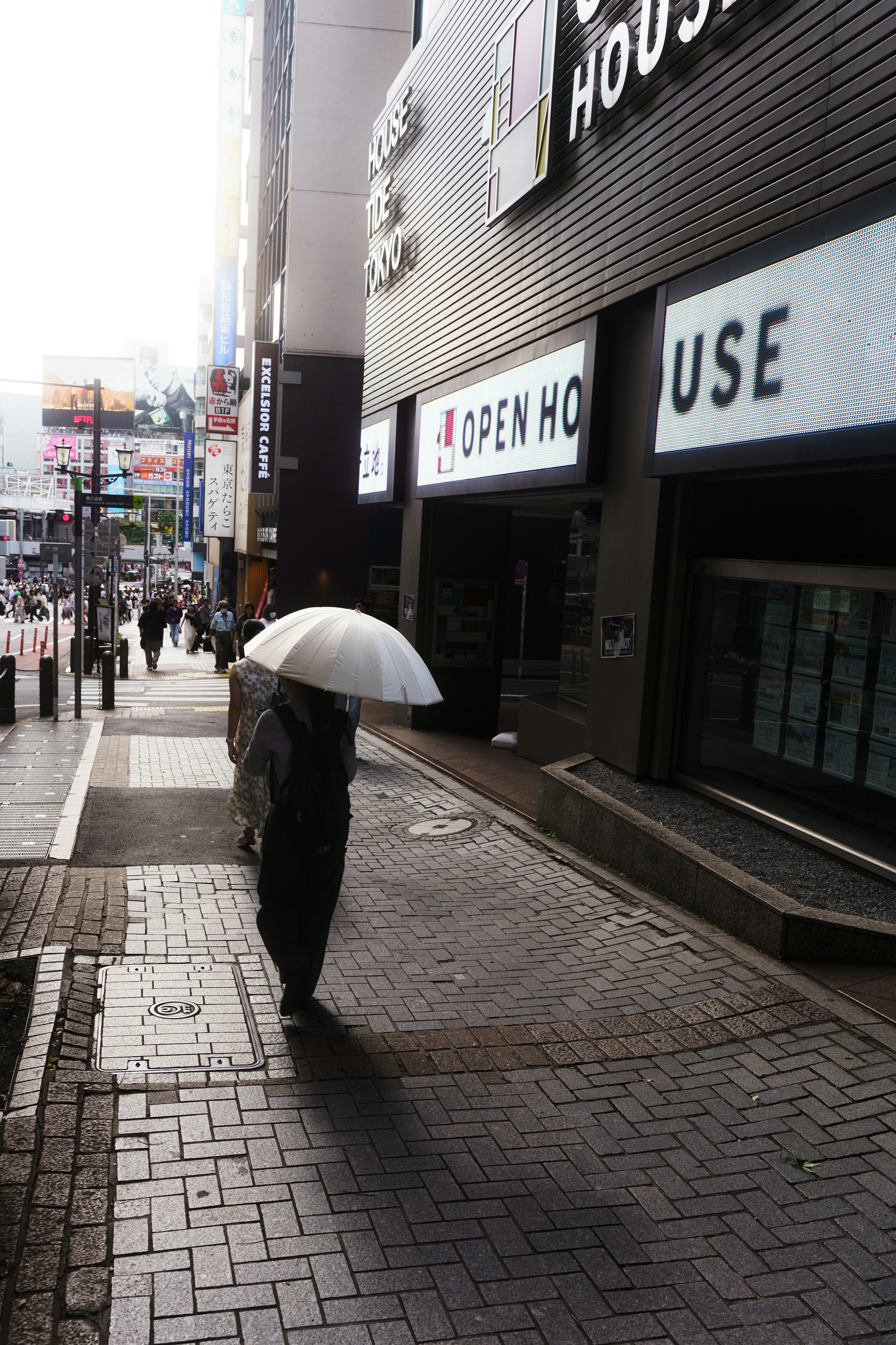 Une silhouette marchant avec un parapluie dans un cadre urbain Bâtiment avec un panneau 'OPEN HOUSE'