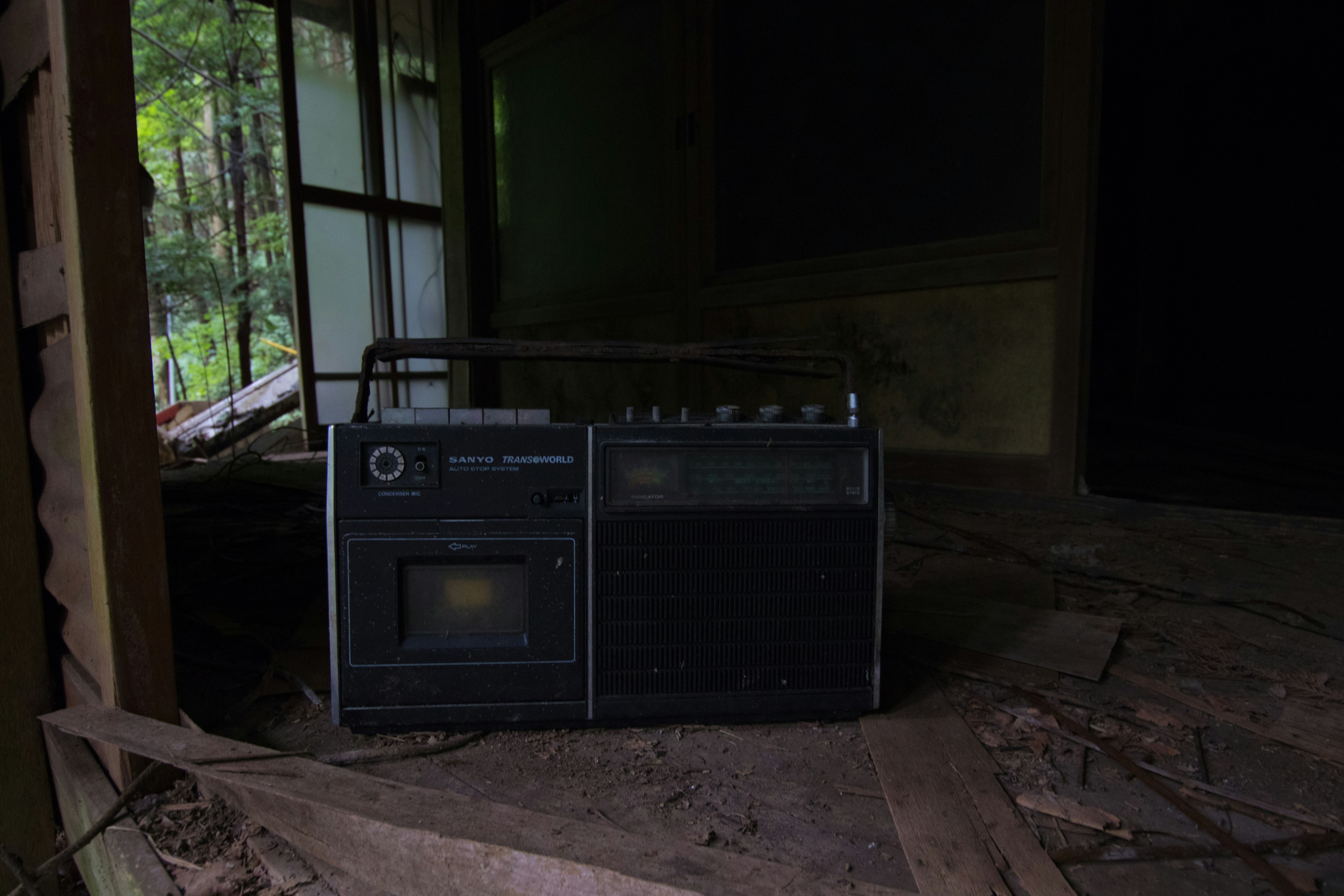 An old radio placed in an abandoned room surrounded by debris