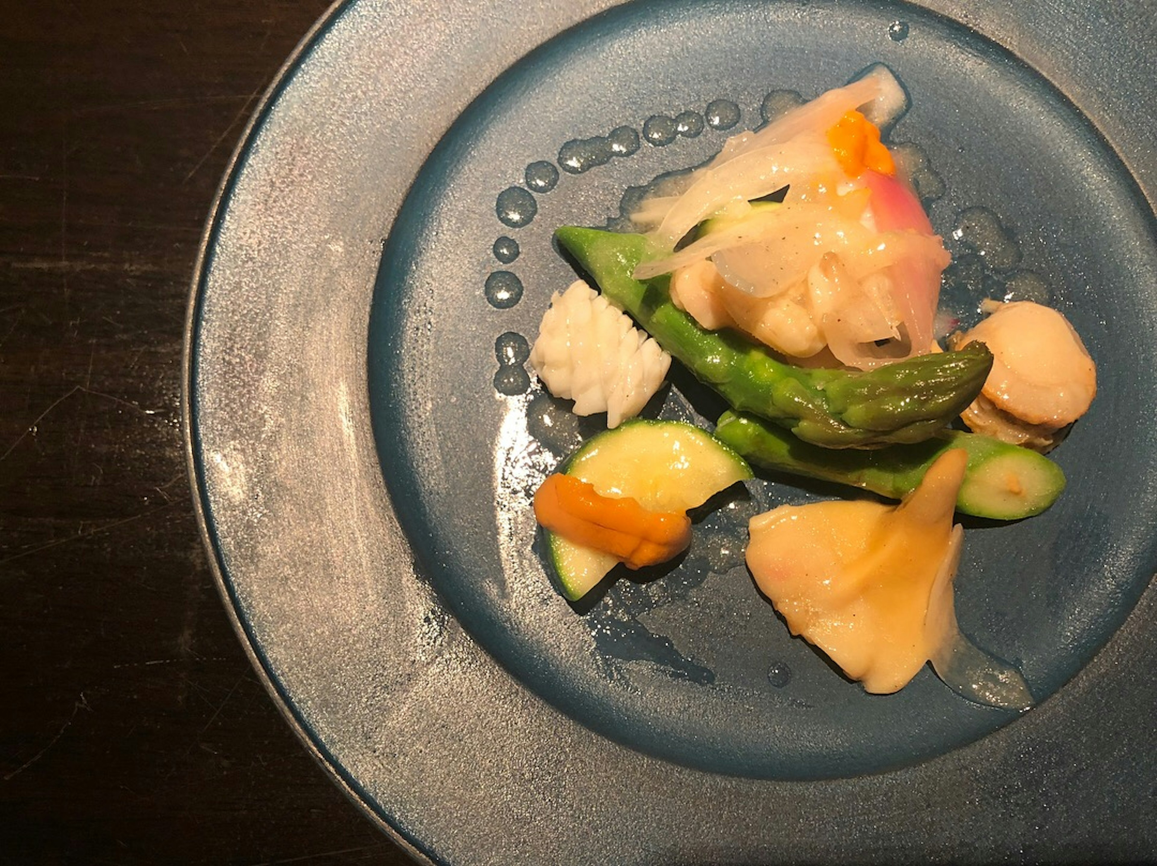 Un plat coloré de légumes et de fruits disposés sur une assiette bleue