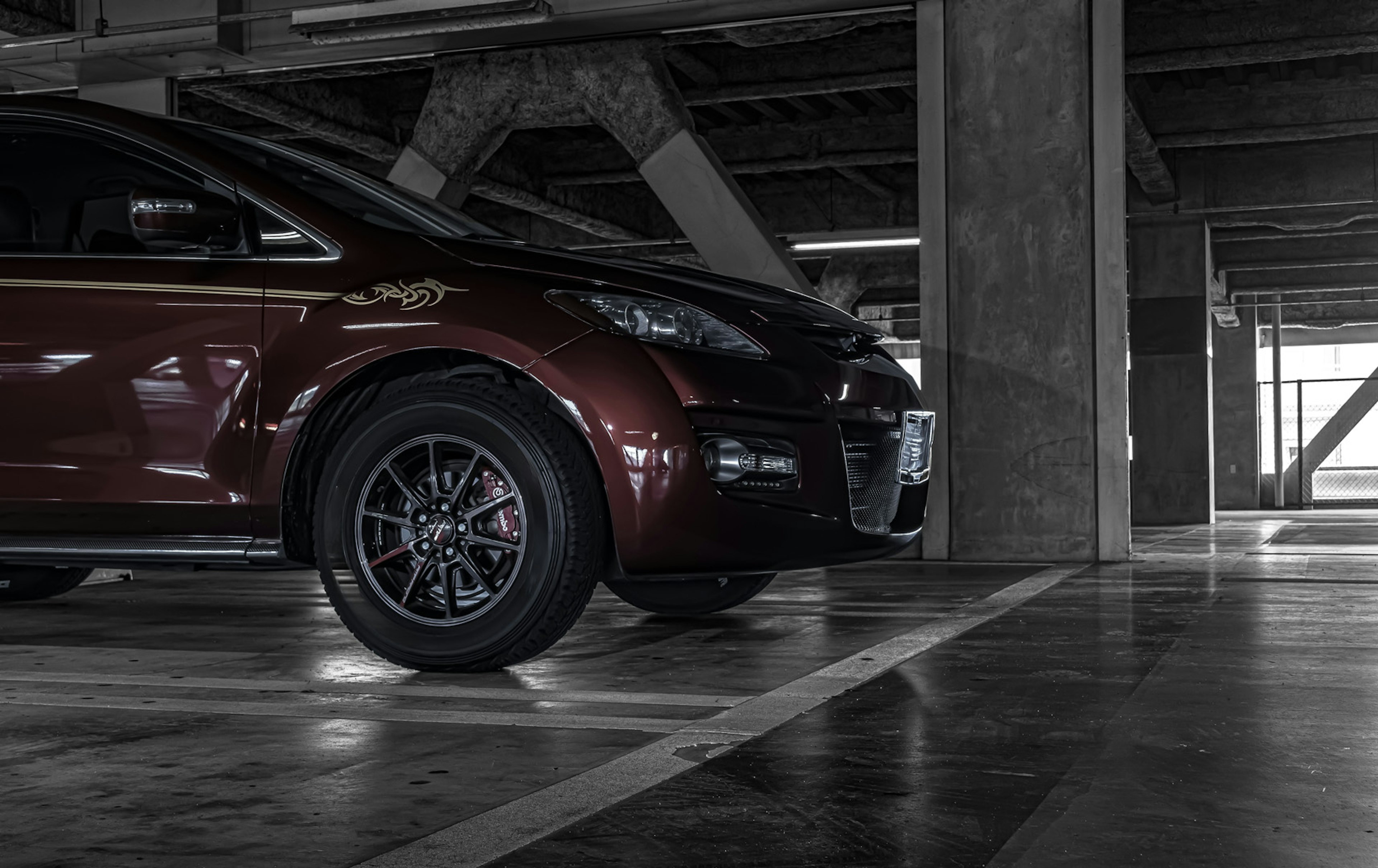 Coche rojo estacionado en un garaje oscuro