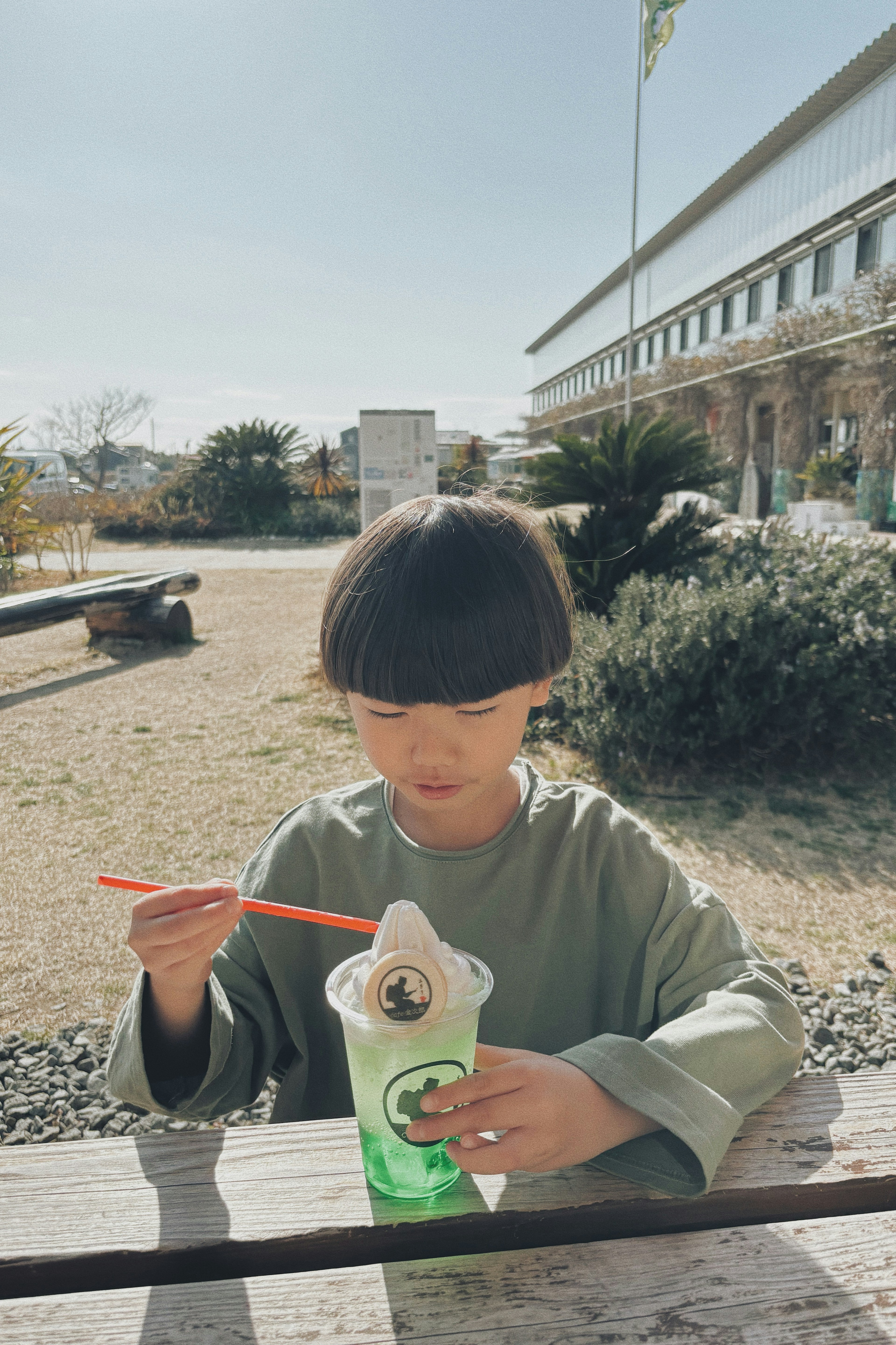 子供が緑の飲み物を飲みながら楽しんでいる風景