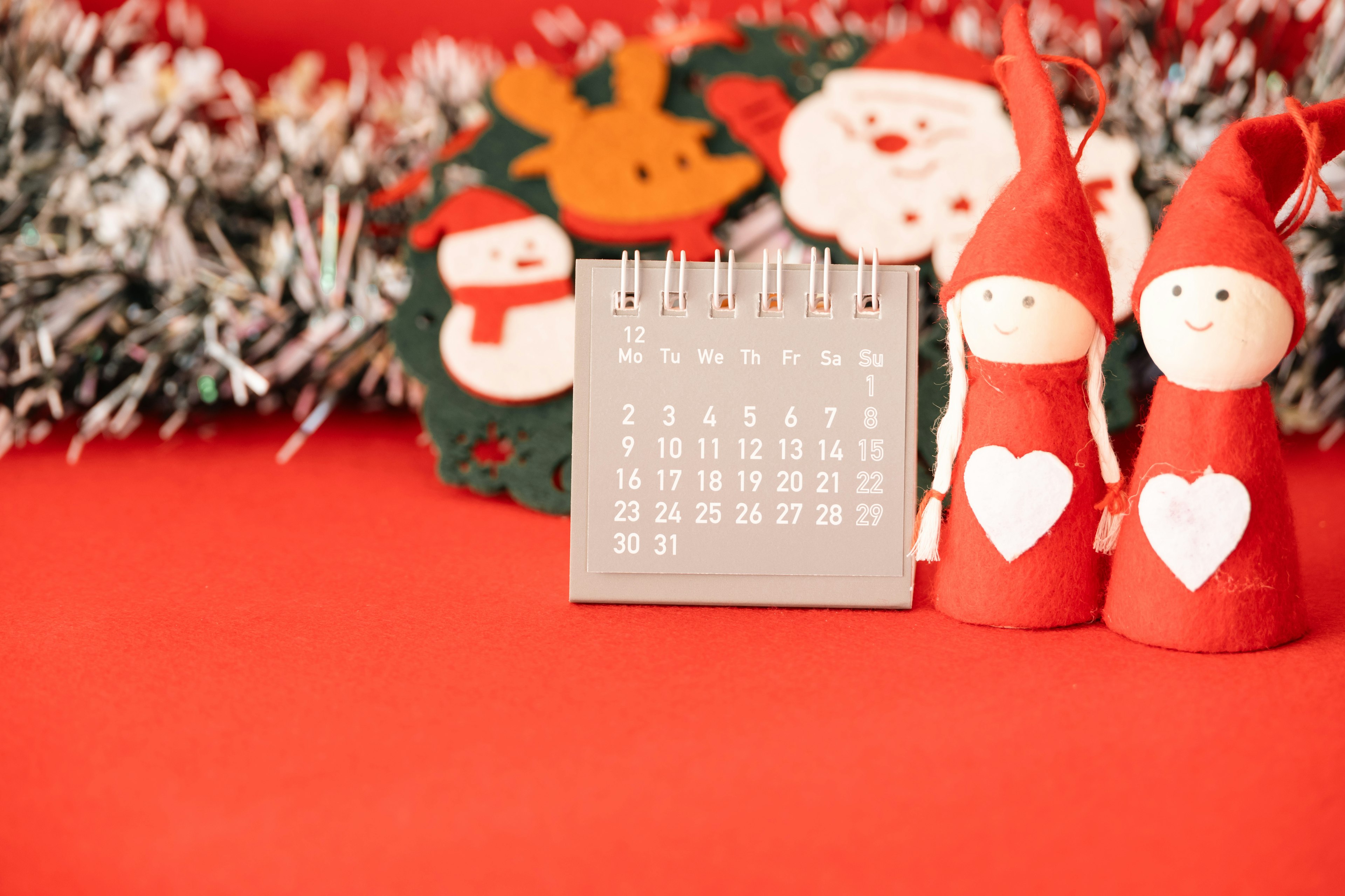 Adegan dengan dekorasi Natal dan kalender di latar belakang merah