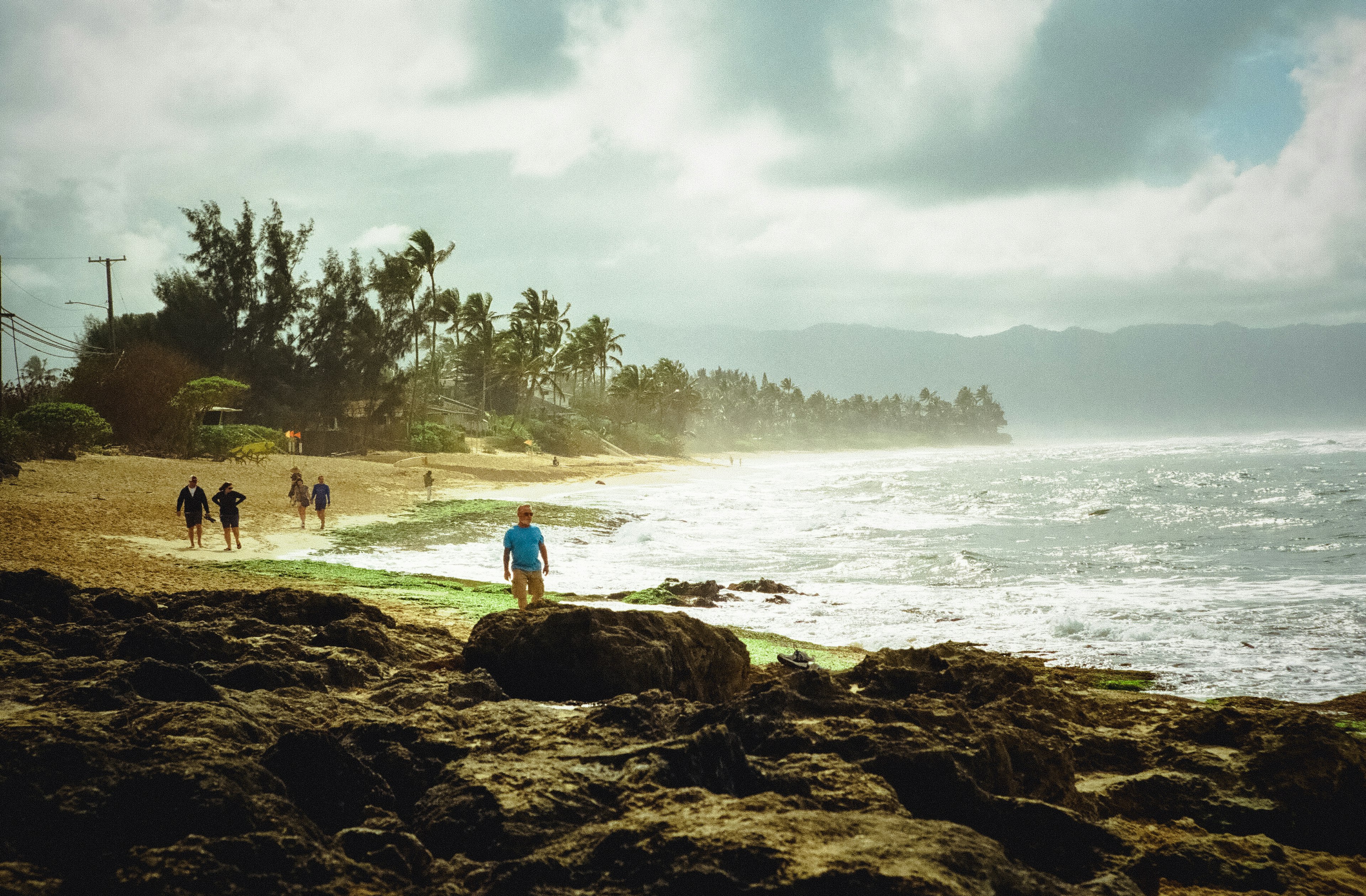 Coastal scene with people walking along the beach and waves