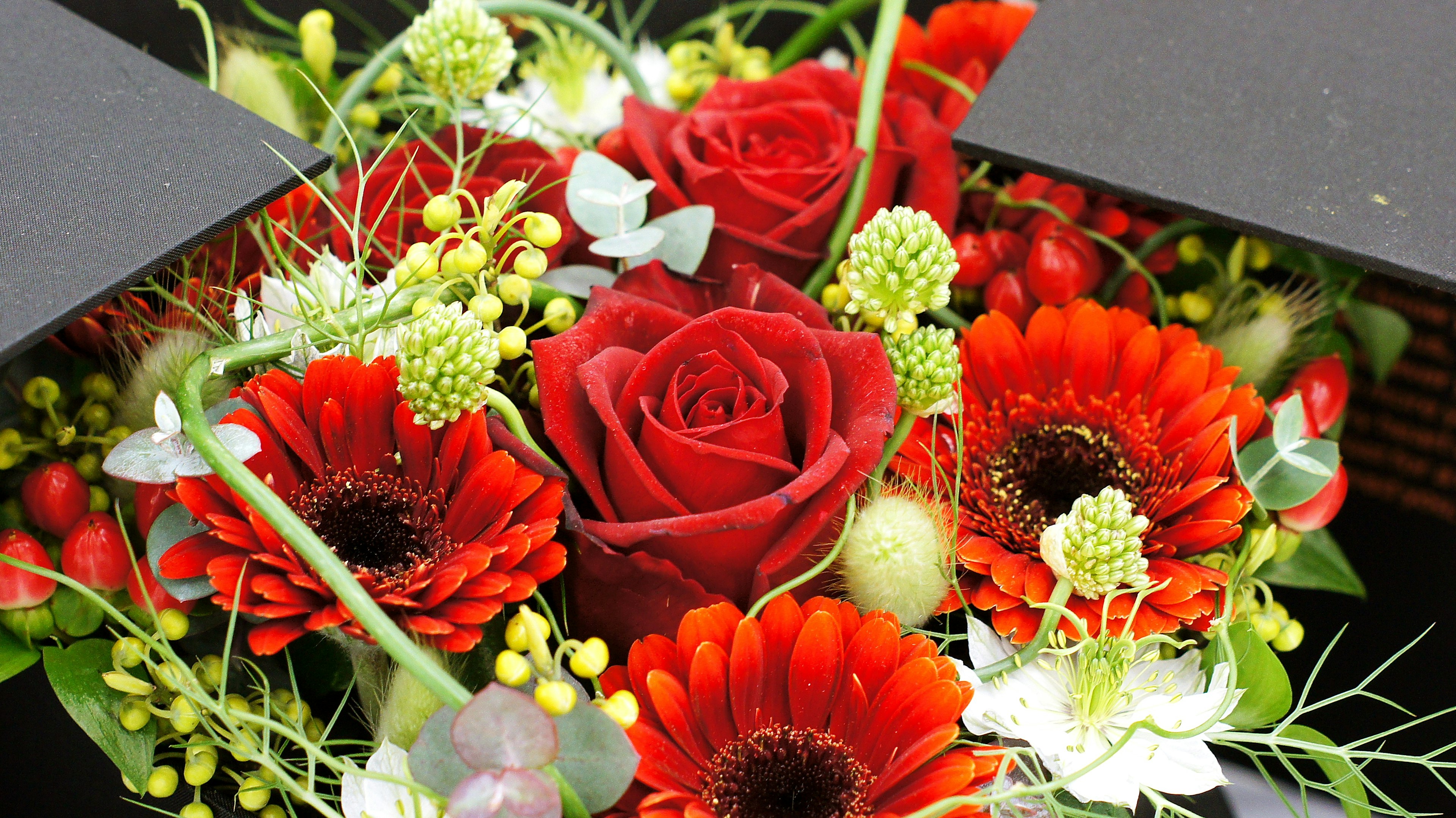 Bellissimo bouquet con rose rosse e fiori arancioni