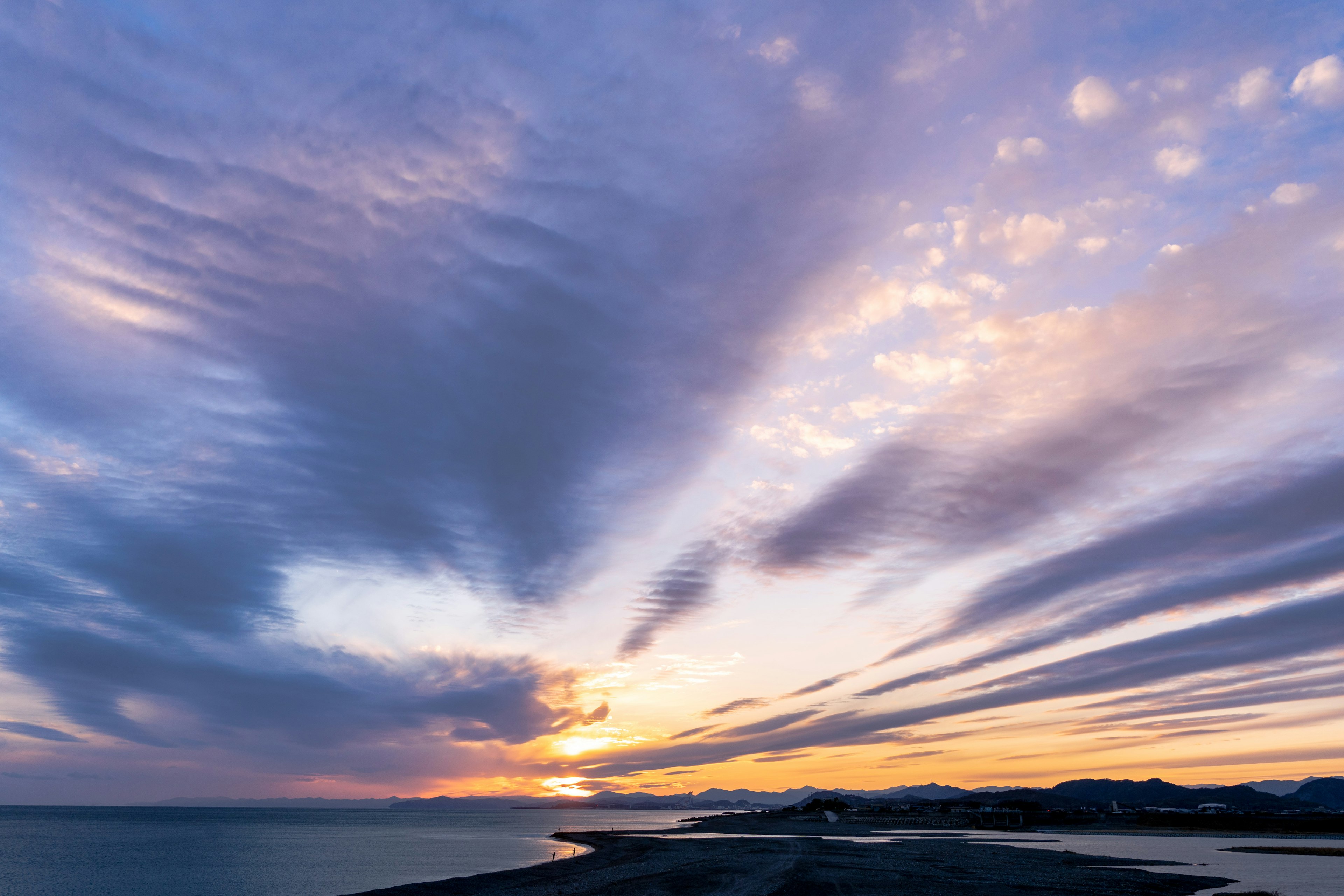 美しい夕焼けの空に広がる雲と海の風景