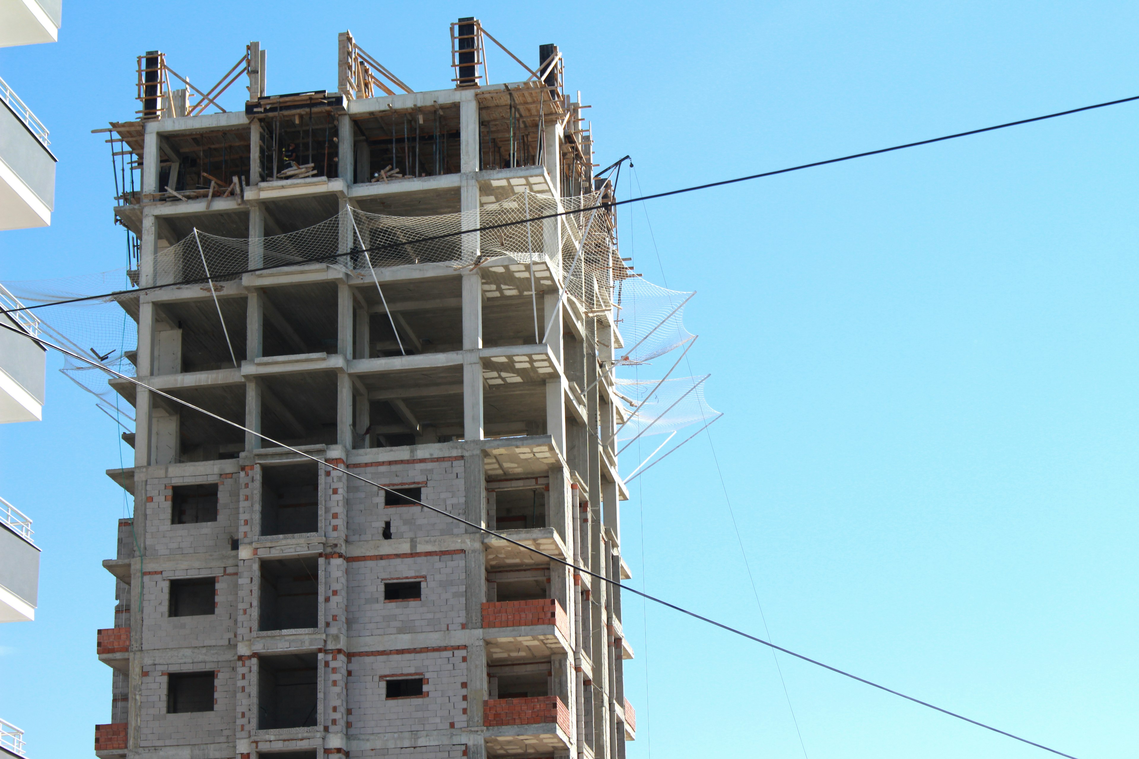 Photo d'un immeuble de grande hauteur en construction montrant une structure en béton sous un ciel bleu