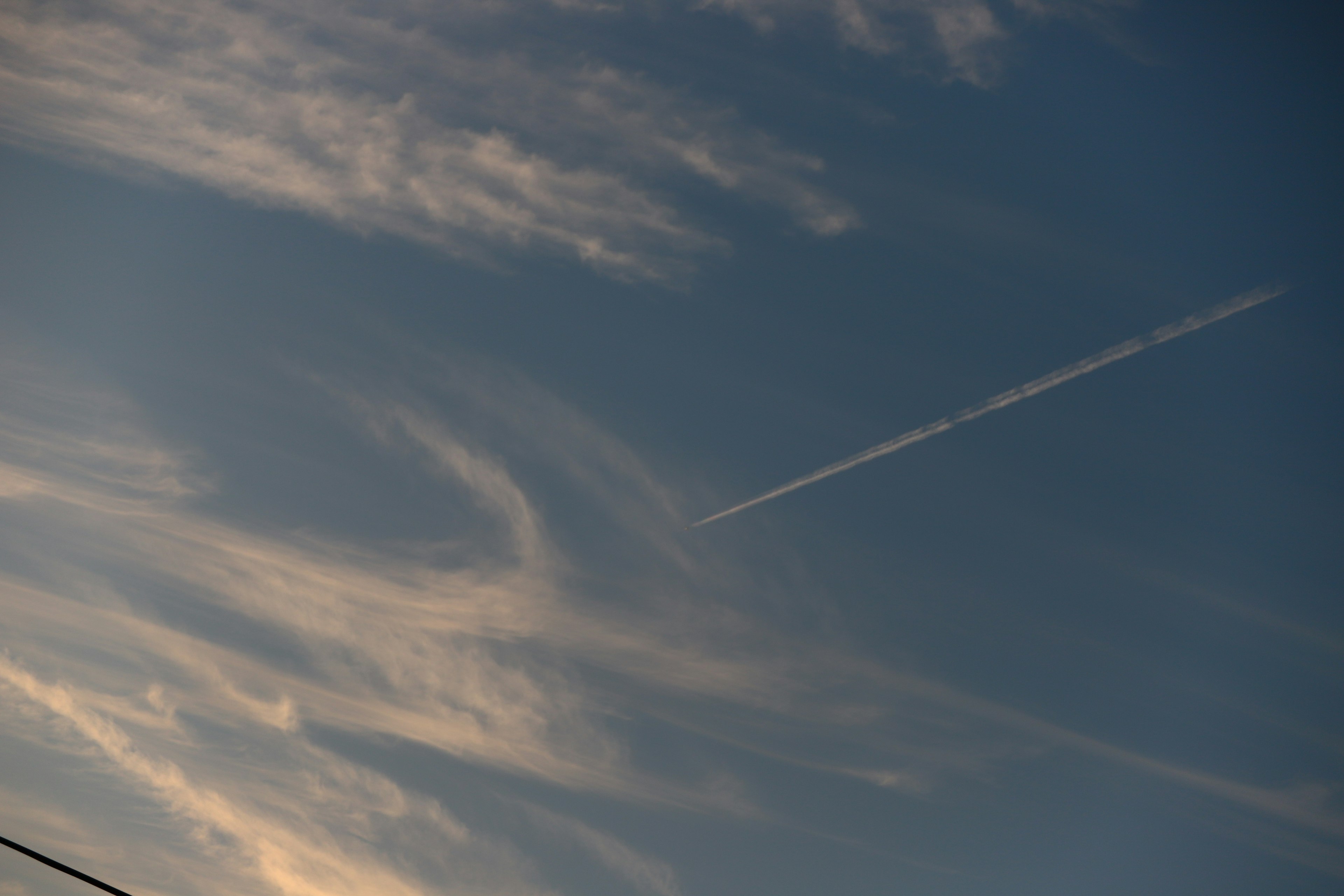 Cielo blu con nuvole e scia di aereo