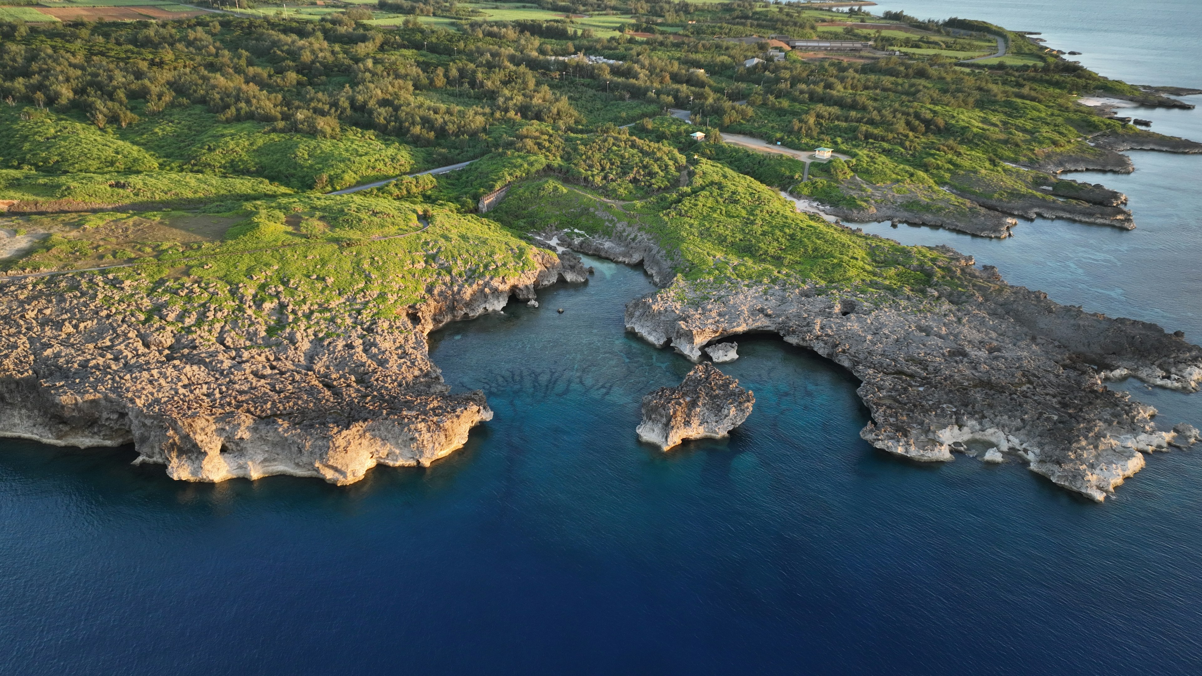 Lush coastal landscape with rocky formations and blue waters