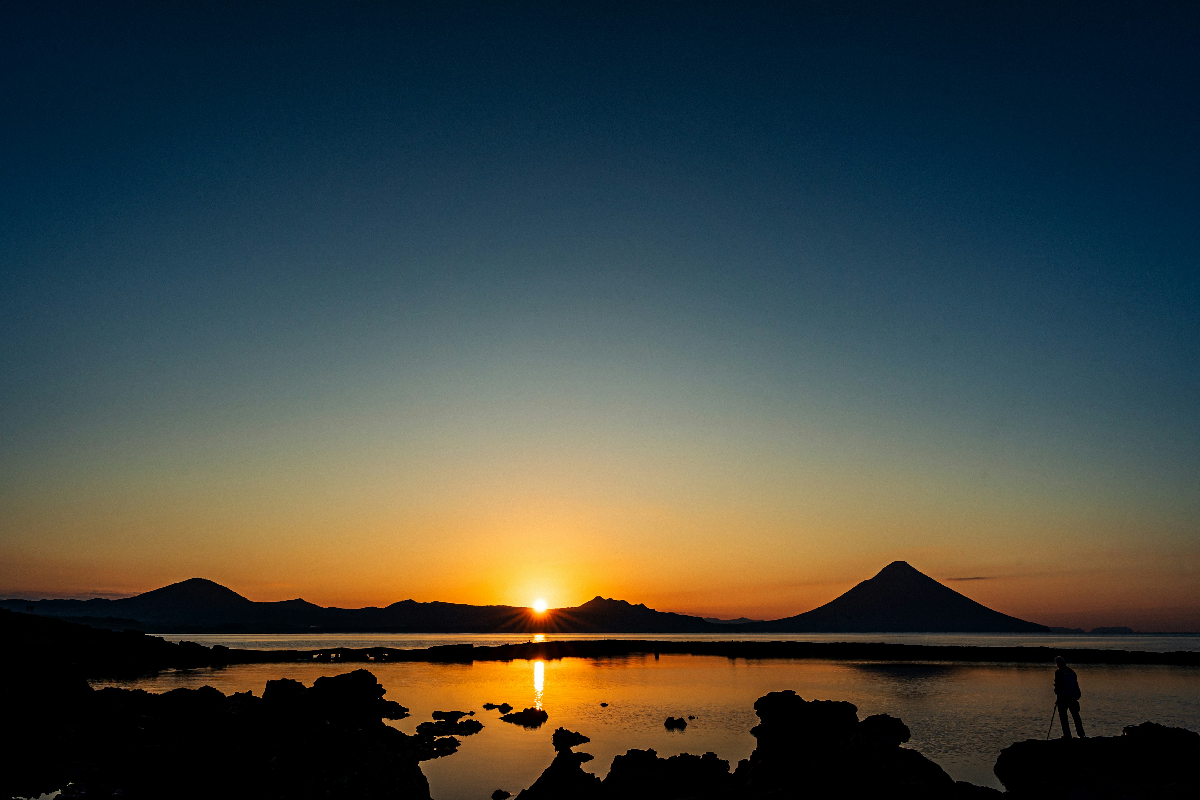 美しい夕焼けの海と山の景色