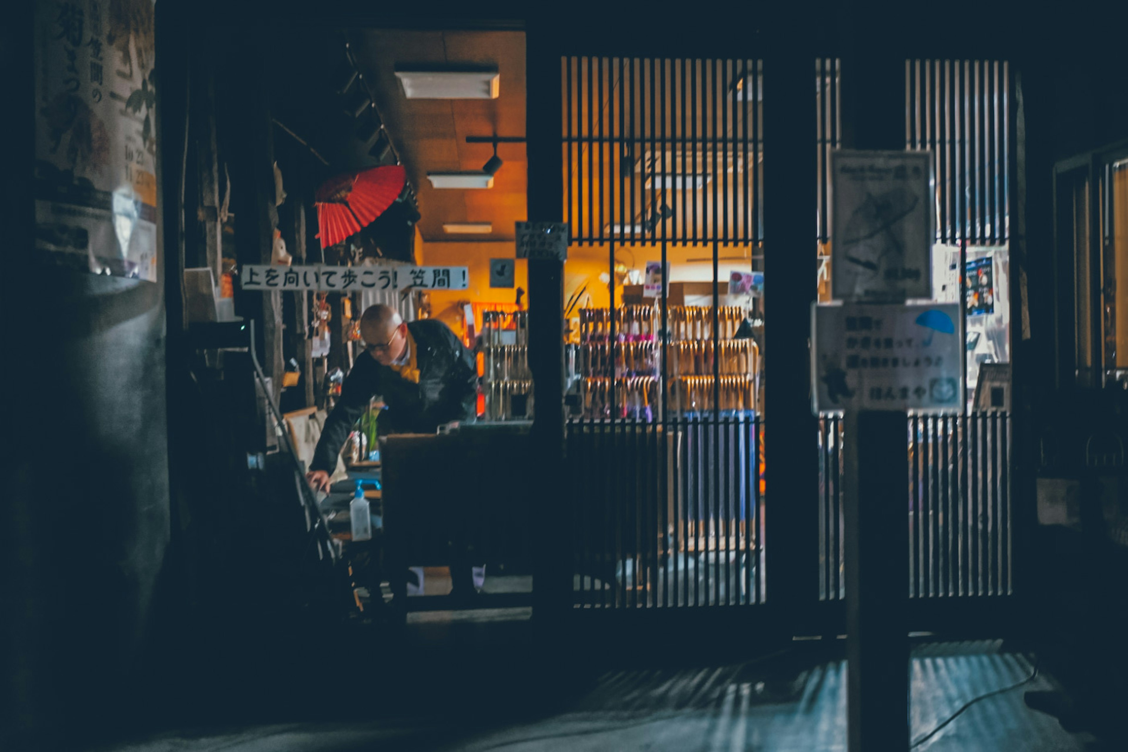 Une personne travaillant dans une librairie faiblement éclairée avec des étagères visibles