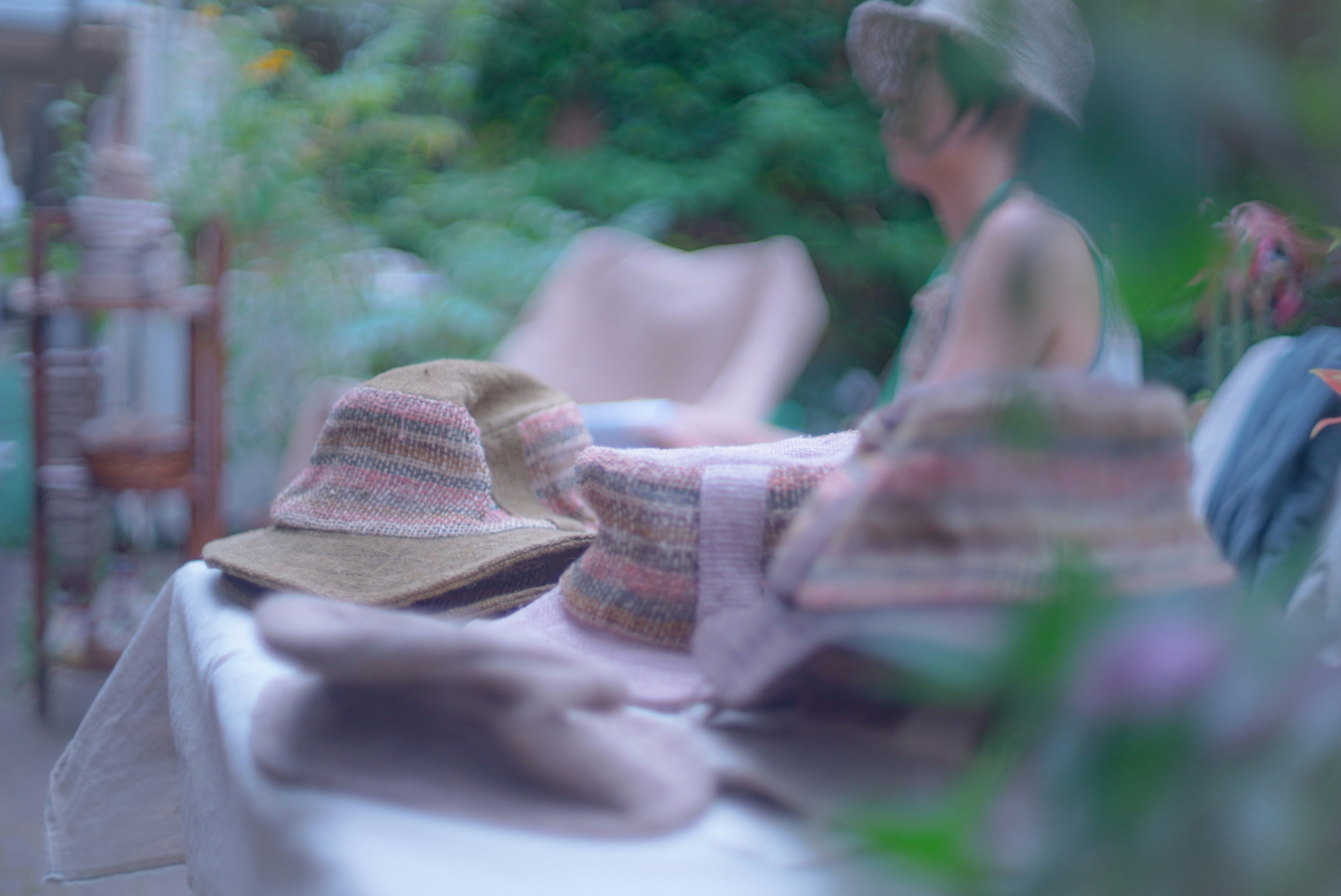 Une collection de chapeaux sur une table avec une figure floue en arrière-plan