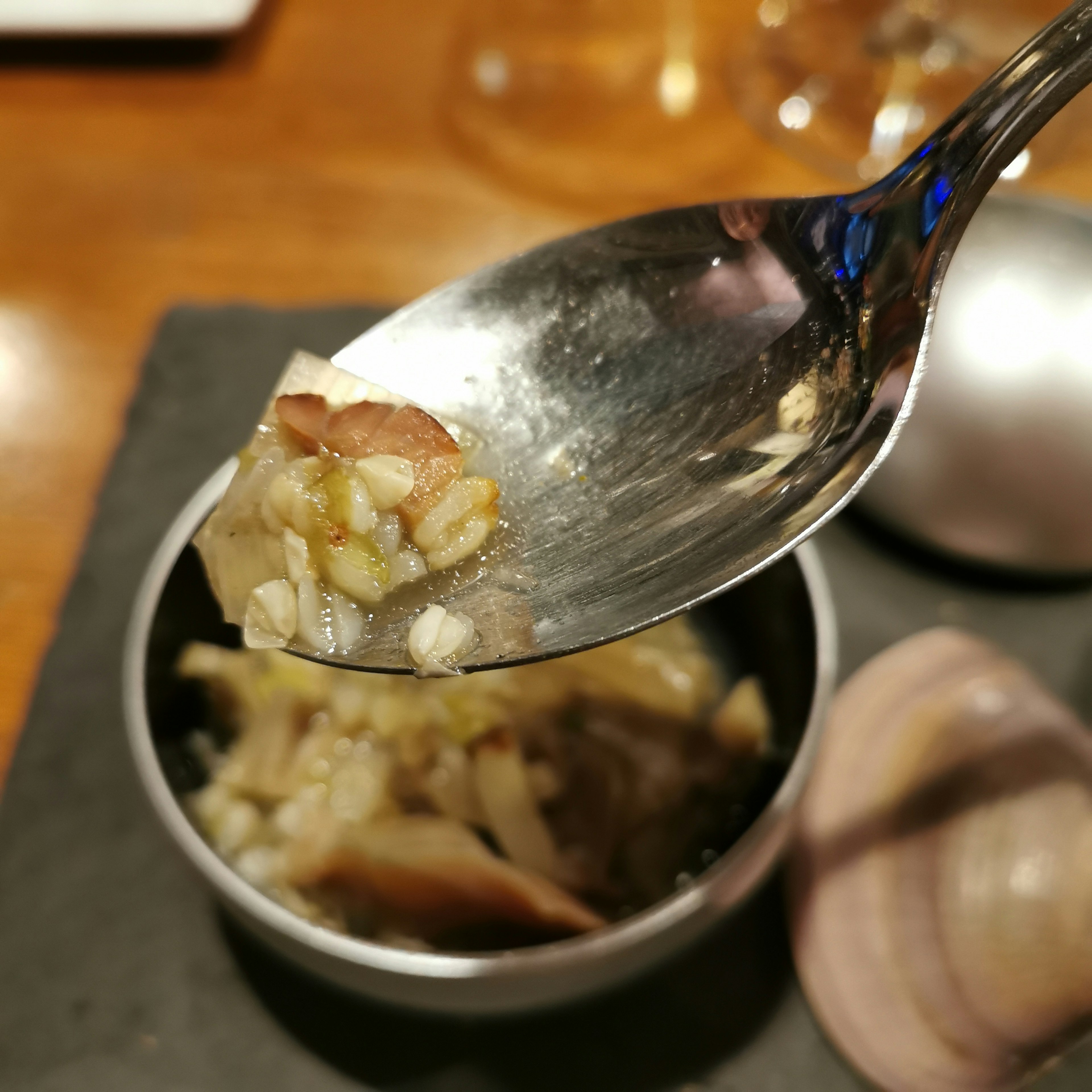 Gericht aus Muscheln und Reis auf einem Löffel serviert