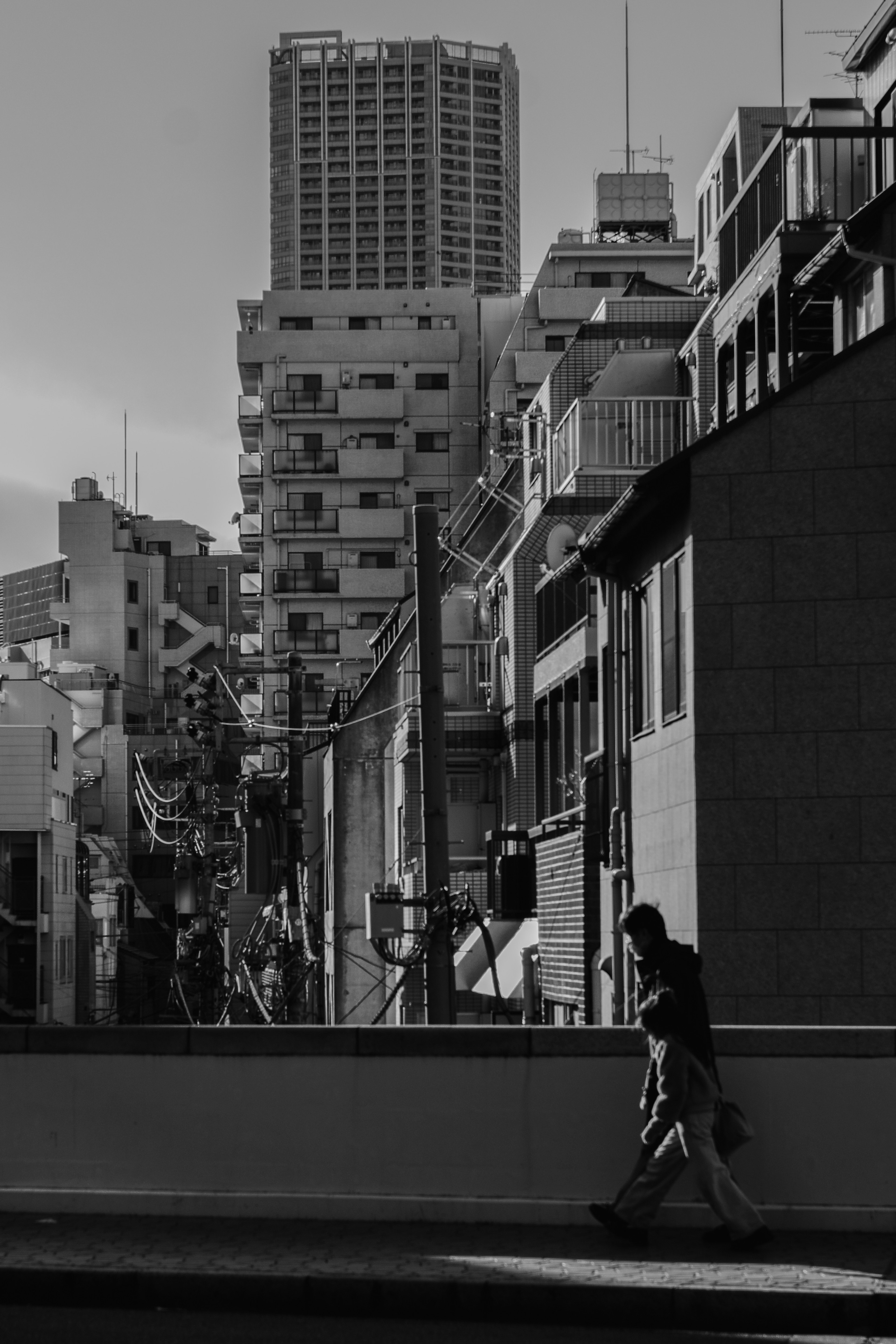 Scène urbaine en noir et blanc avec une figure marchante