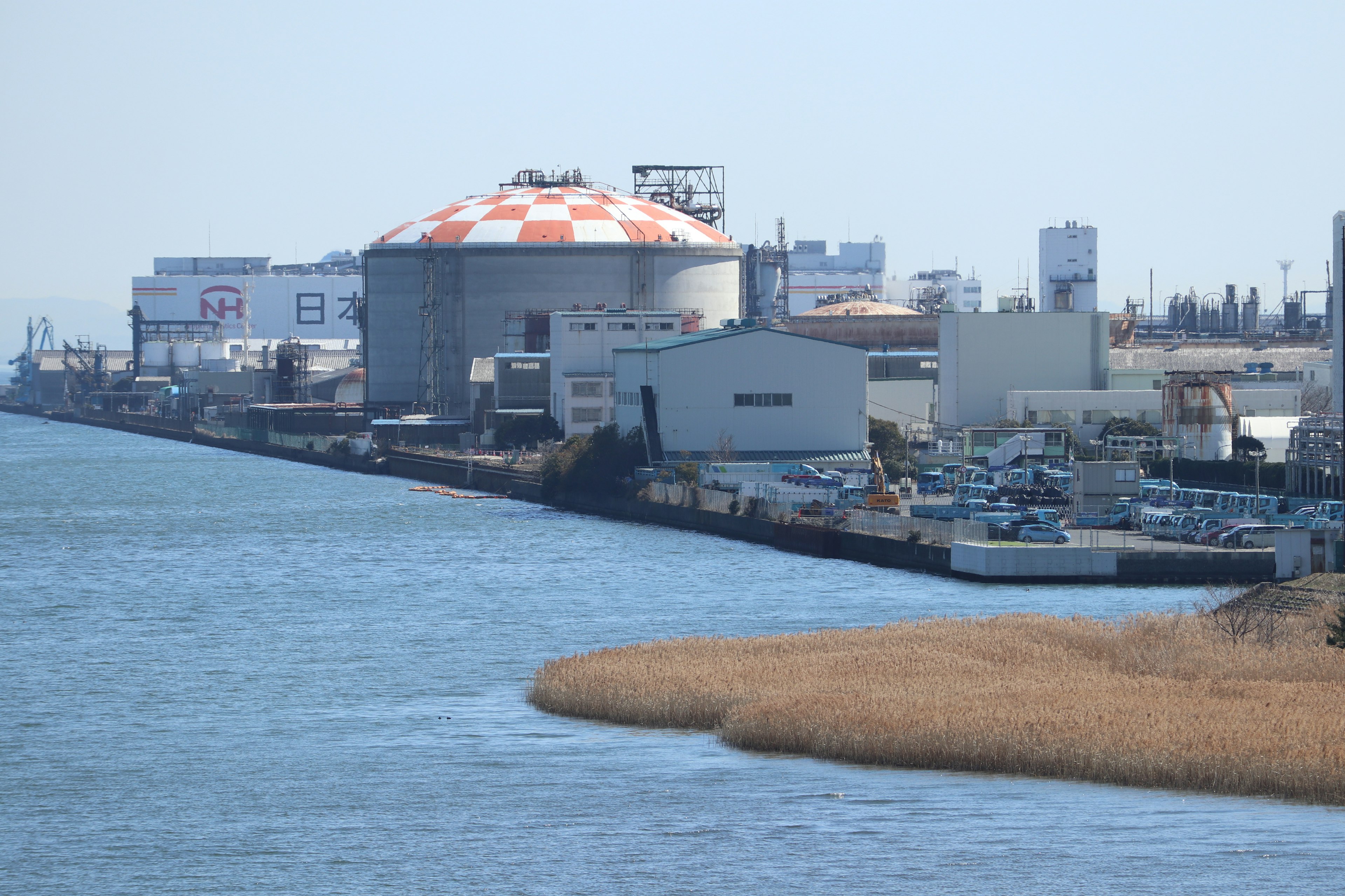 Struttura industriale lungo il fiume con tetto arancione e bianco