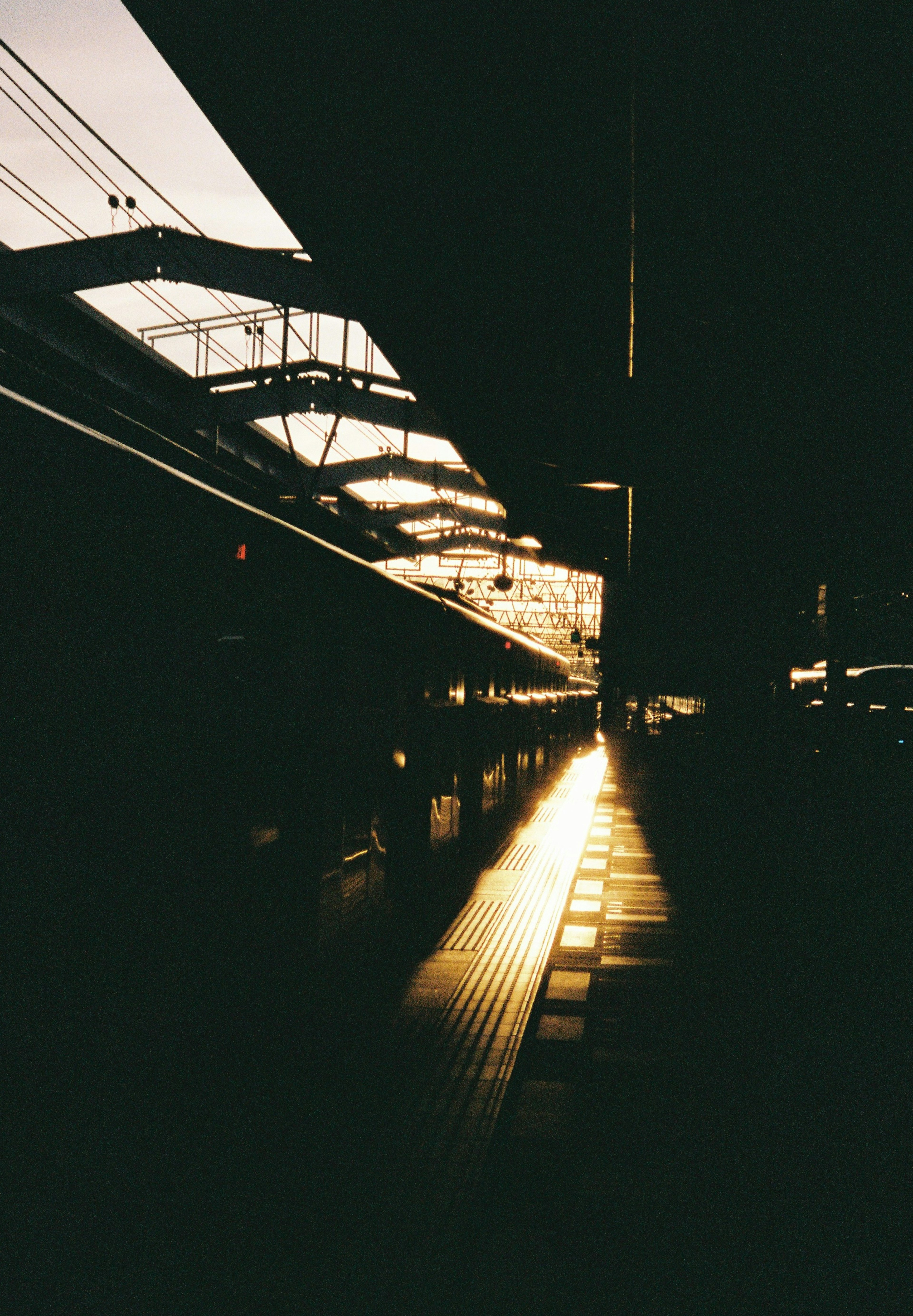 暗い駅のプラットフォームに夕日が照らす