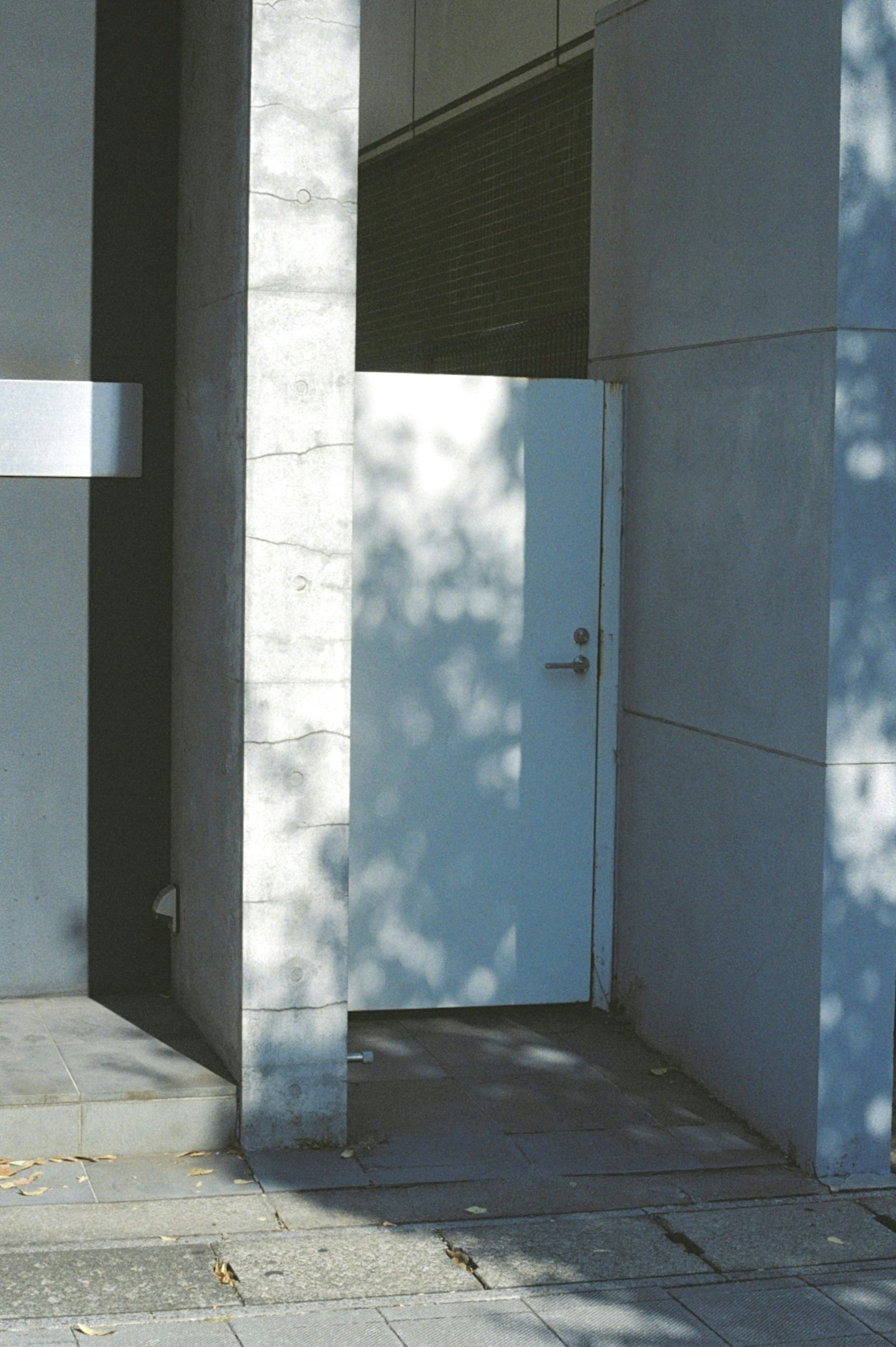 Puerta blanca en la esquina de un edificio moderno de concreto