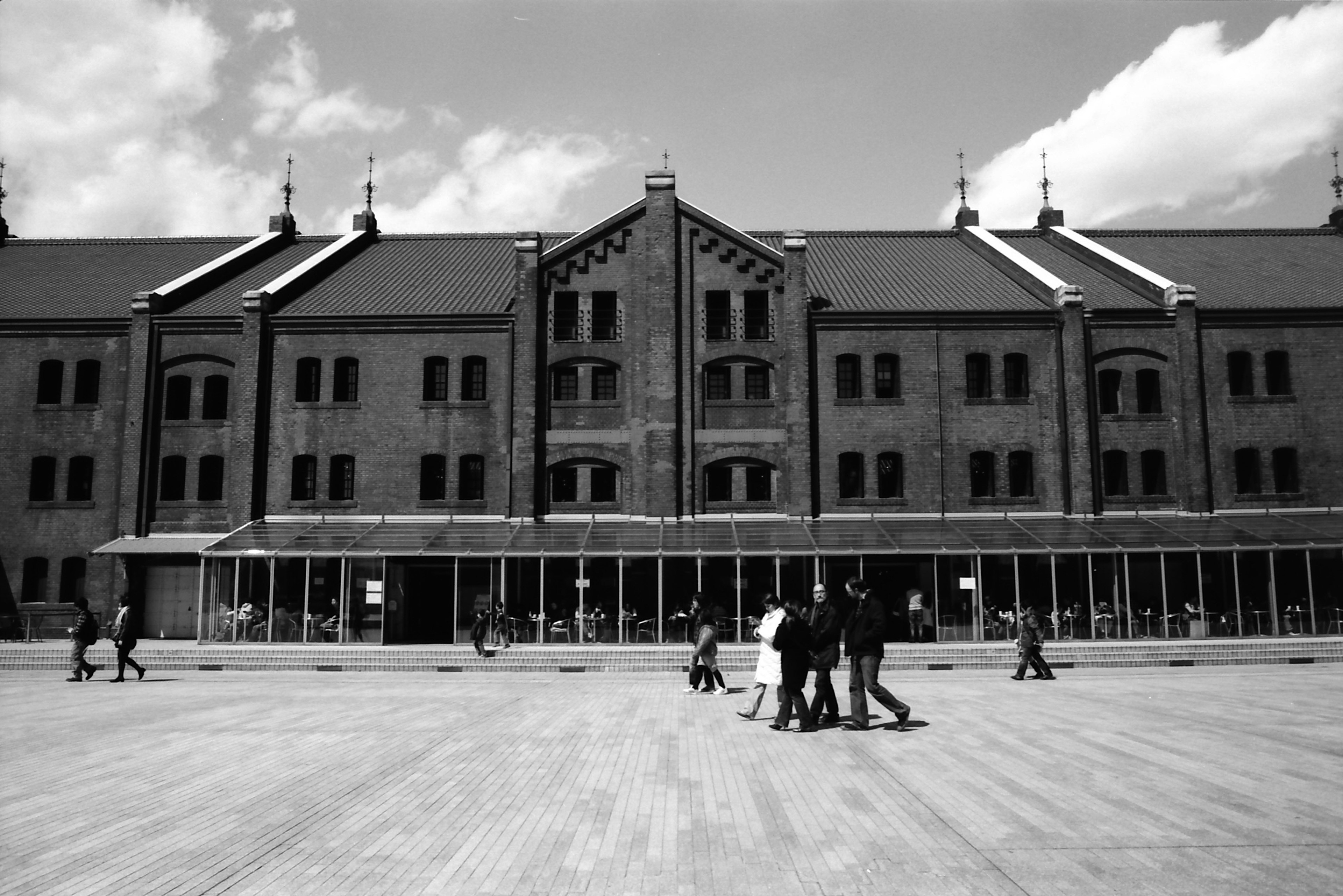 Foto en blanco y negro del Almacén de Ladrillo Rojo de Yokohama con personas caminando en la plaza