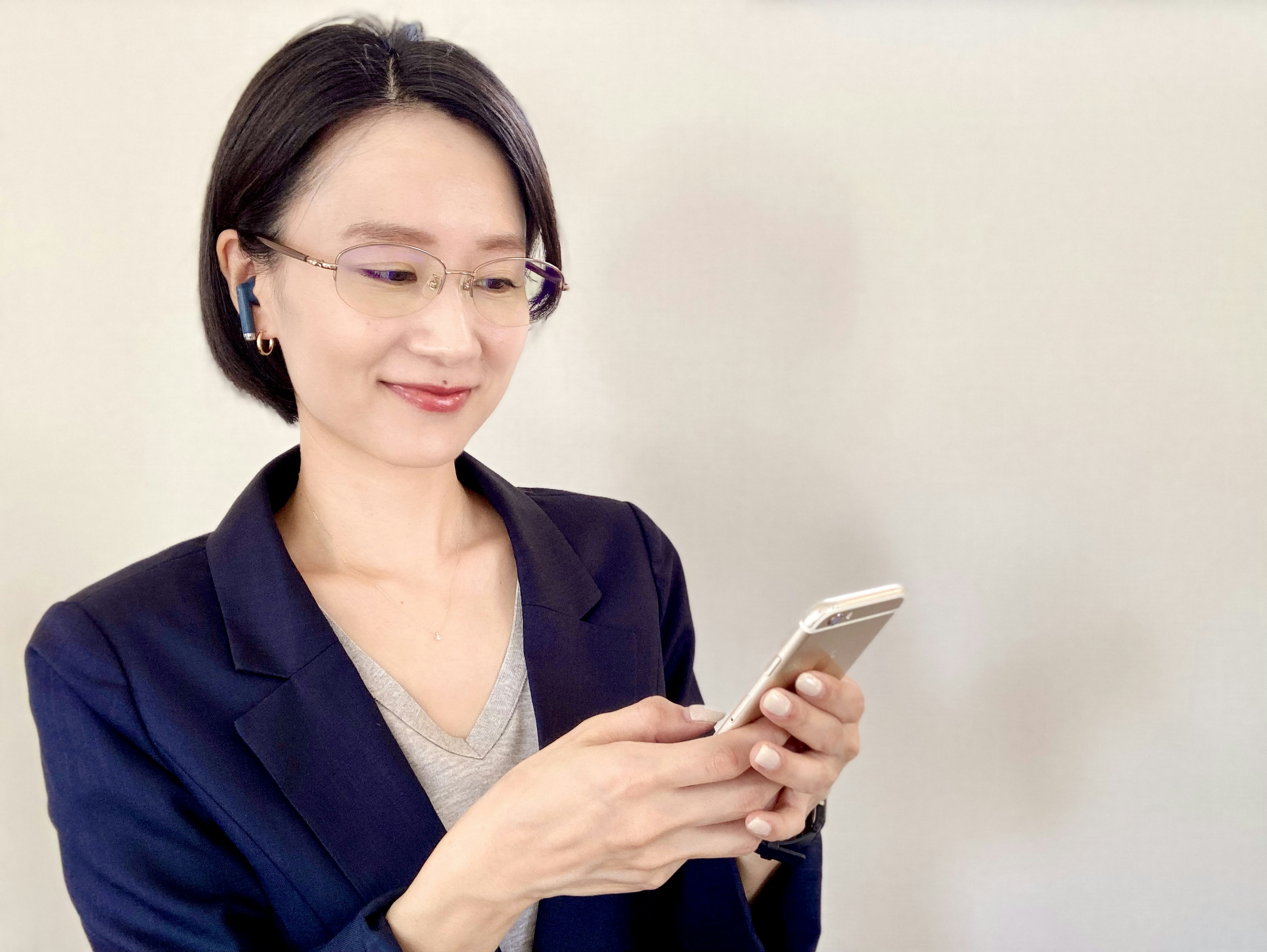 Mujer sonriente con atuendo de negocios usando un smartphone