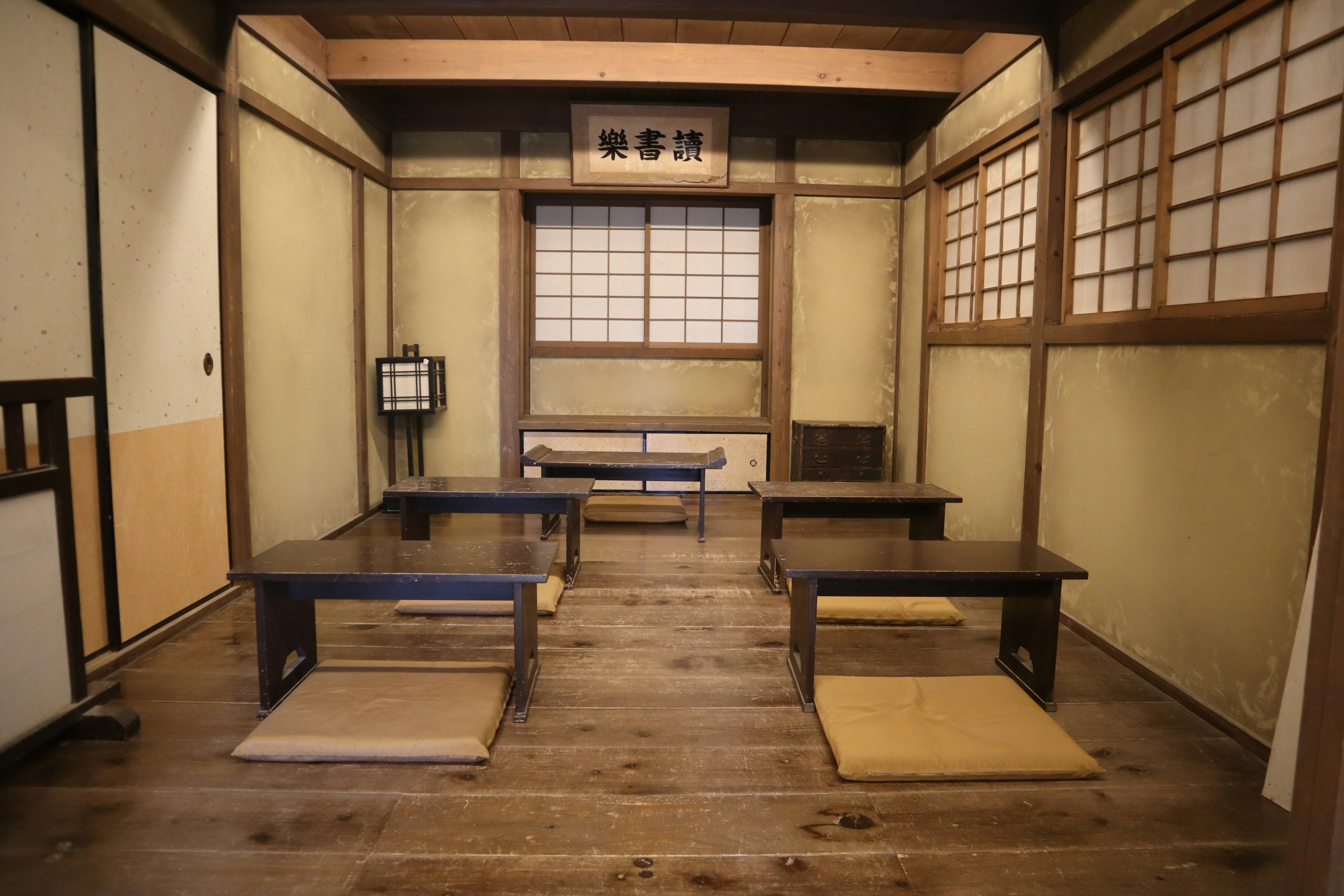 Interior view of a traditional Japanese room featuring tatami mats low tables and cushions