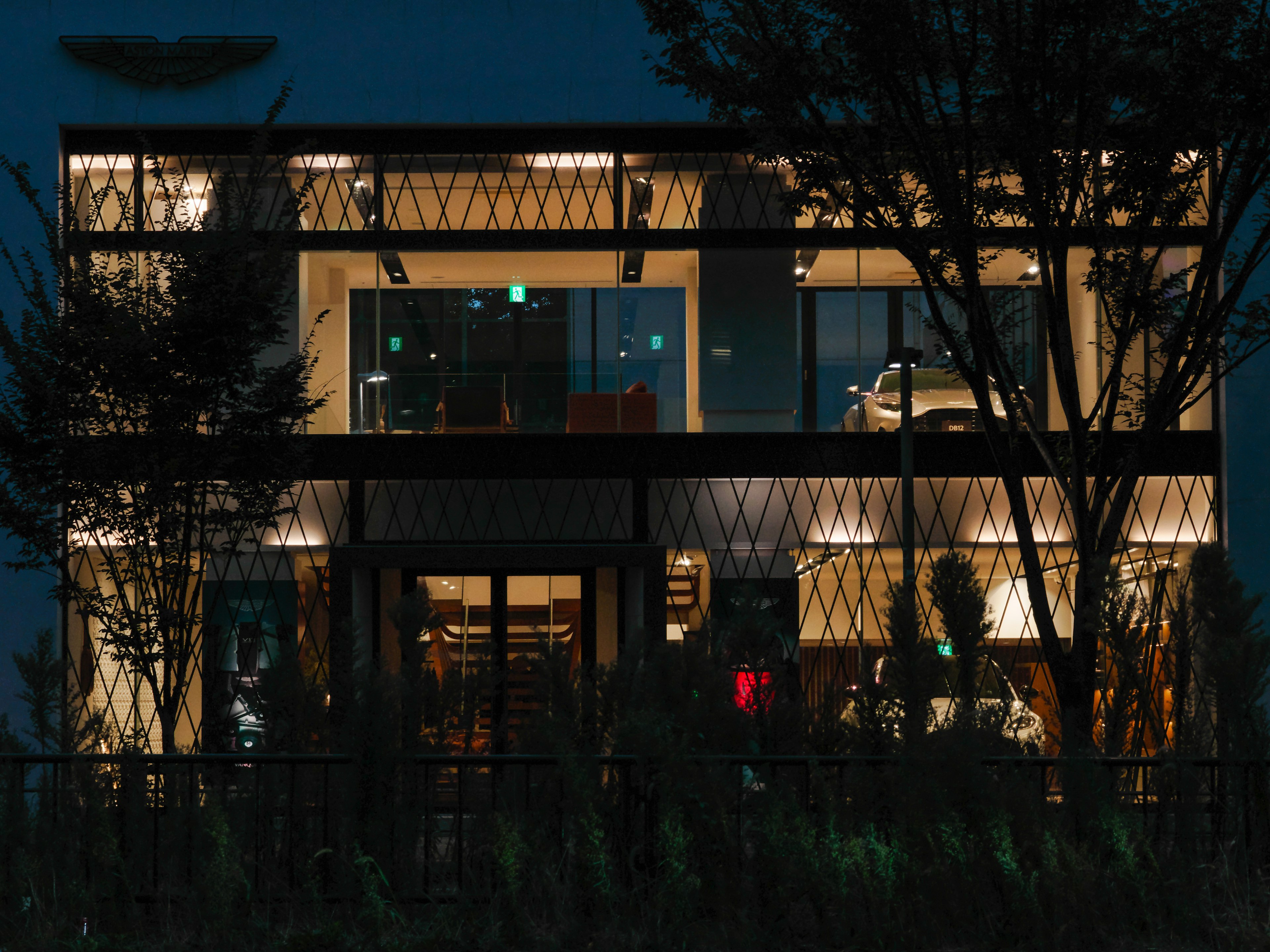 Exterior de un edificio moderno iluminado por la noche en un entorno urbano