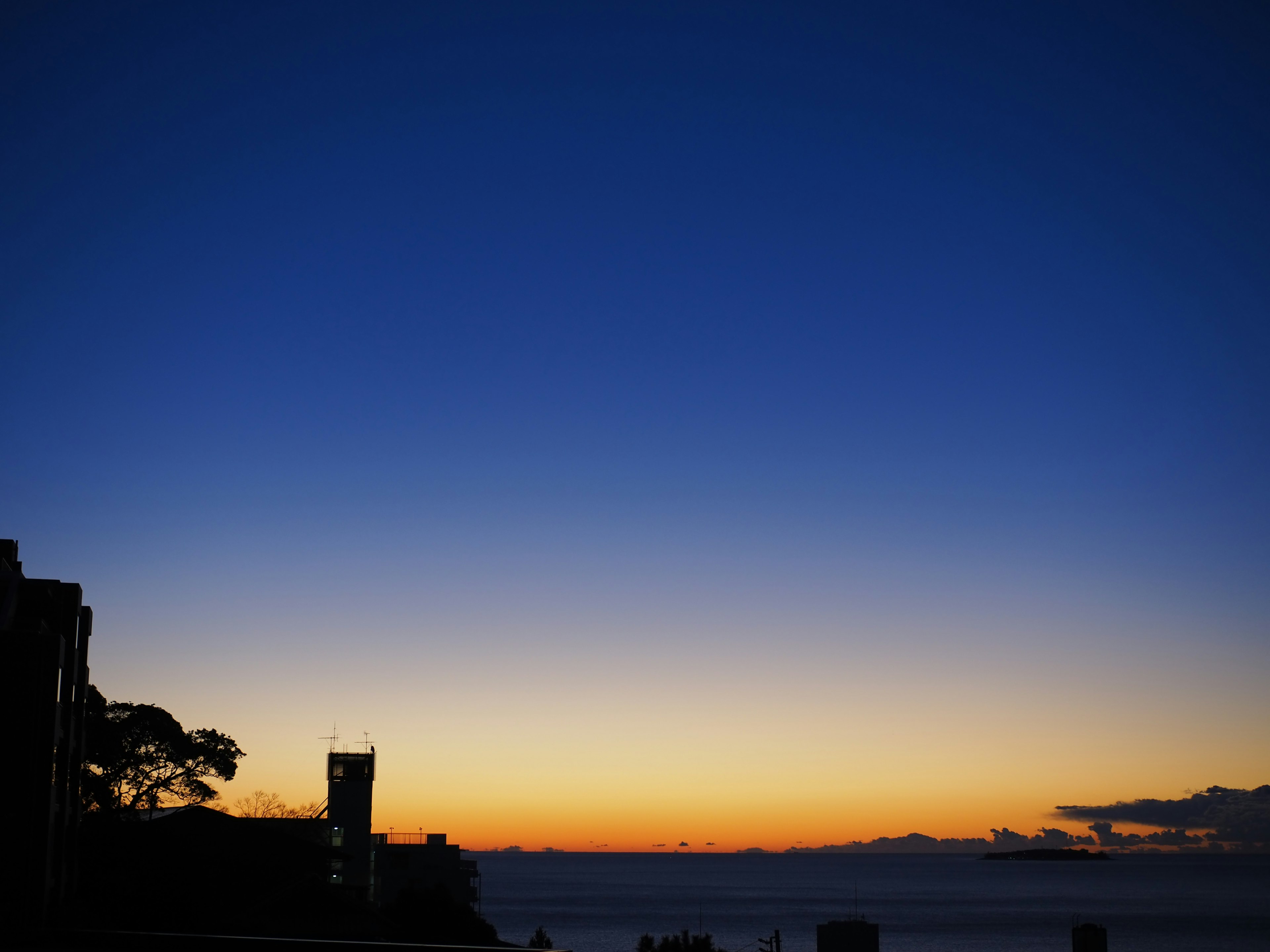 Gradient of blue to orange sky at sunset over the ocean