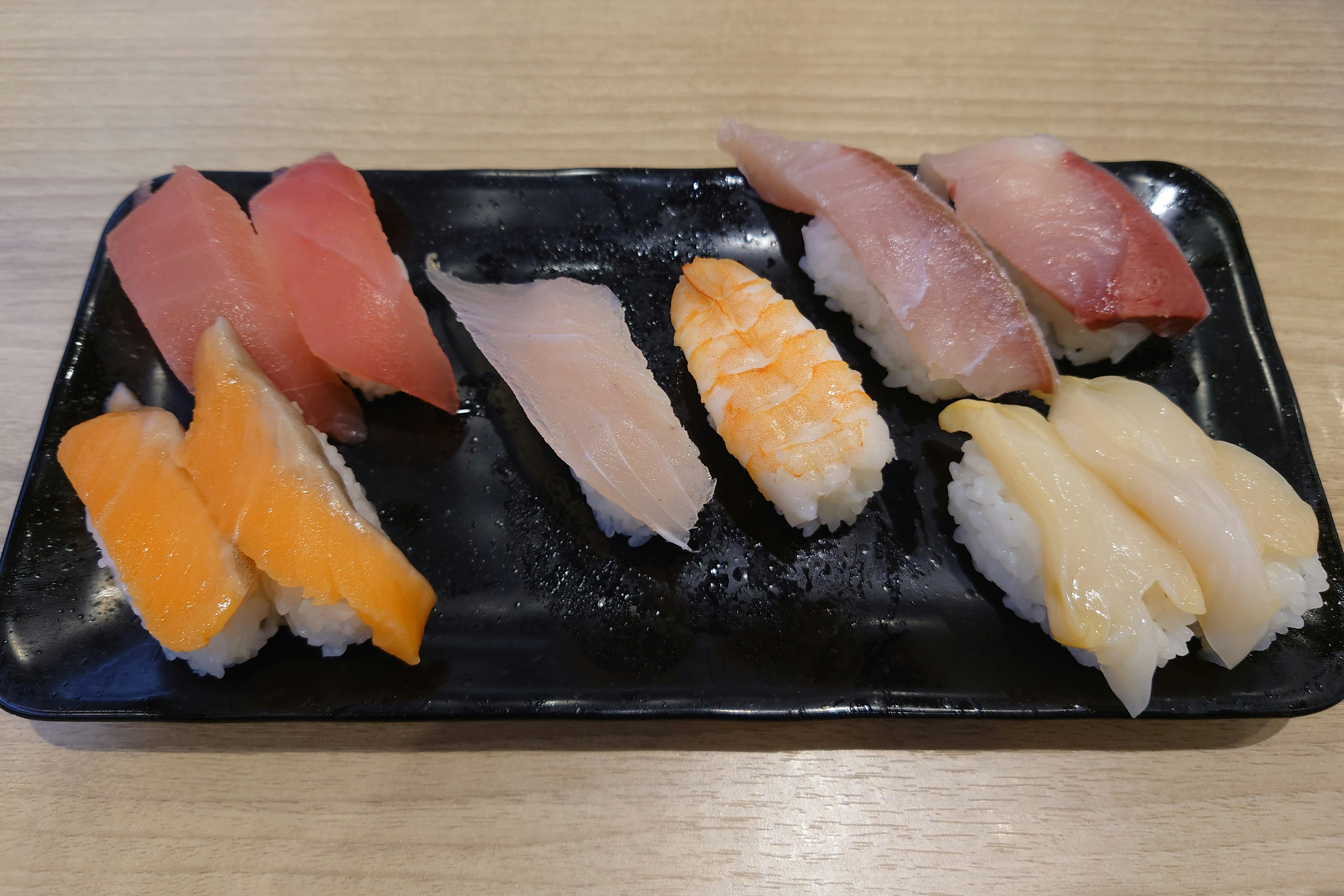 Colorful sushi assortment arranged on a black plate