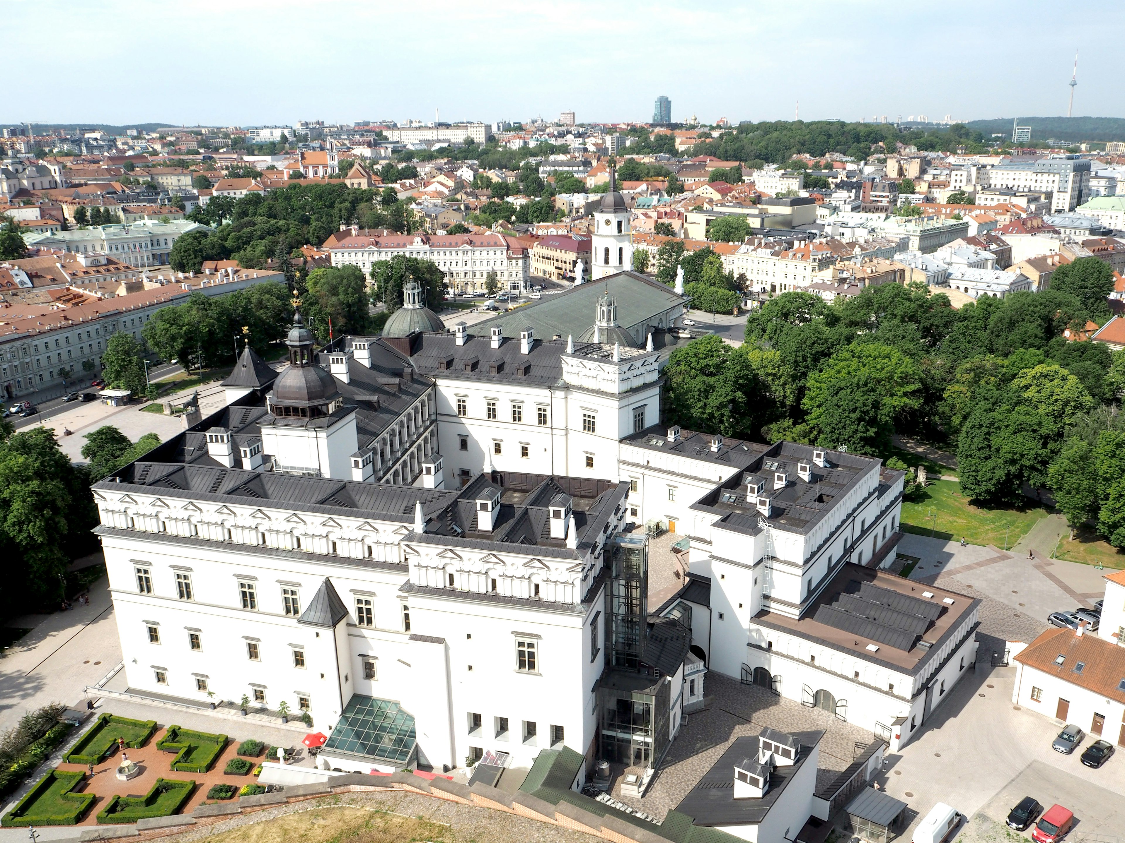 Luftaufnahme eines historischen Palastes mit weißer Architektur und üppigem Grün