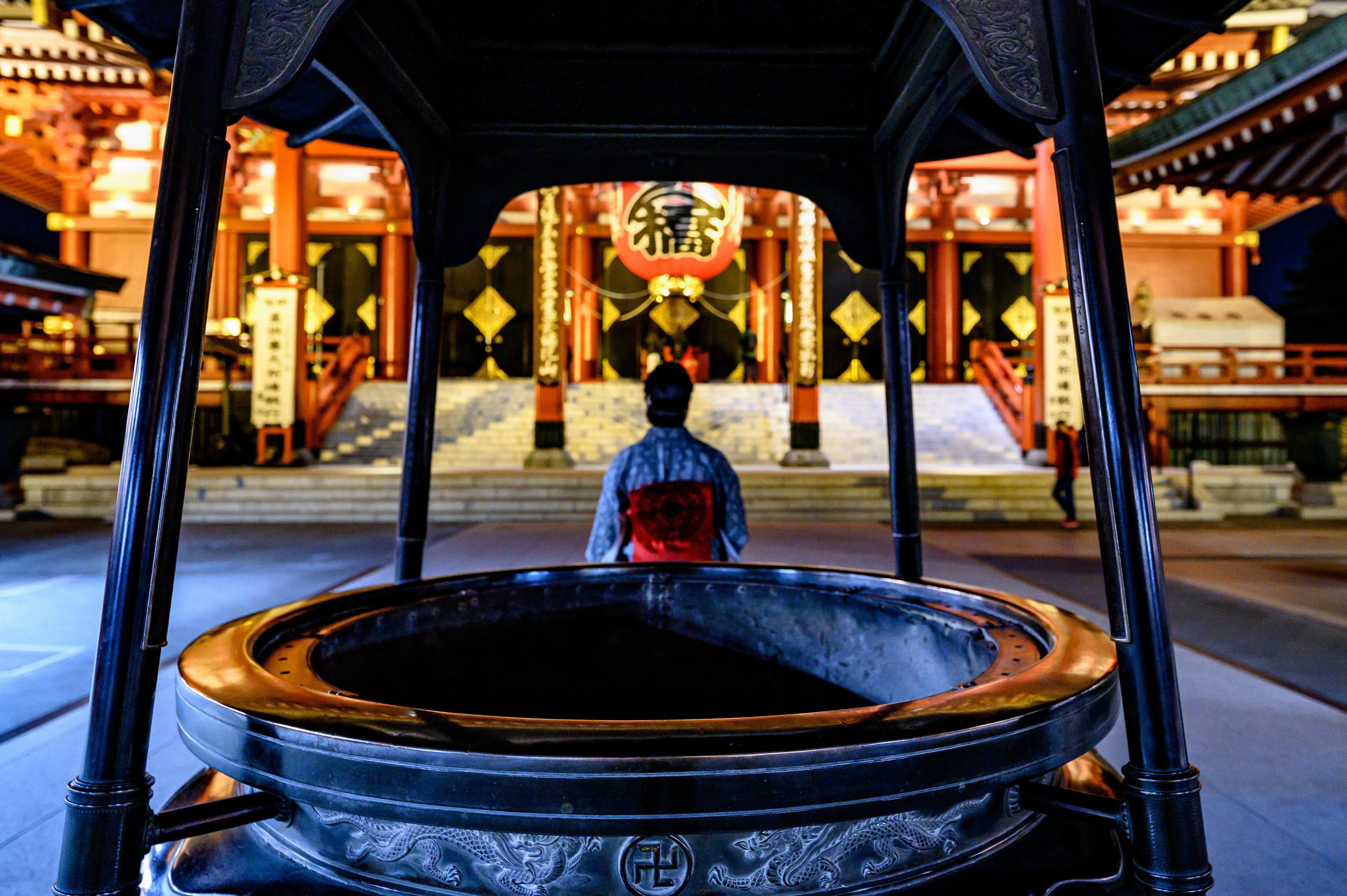 夜の神社で座る人物と美しい建物の照明