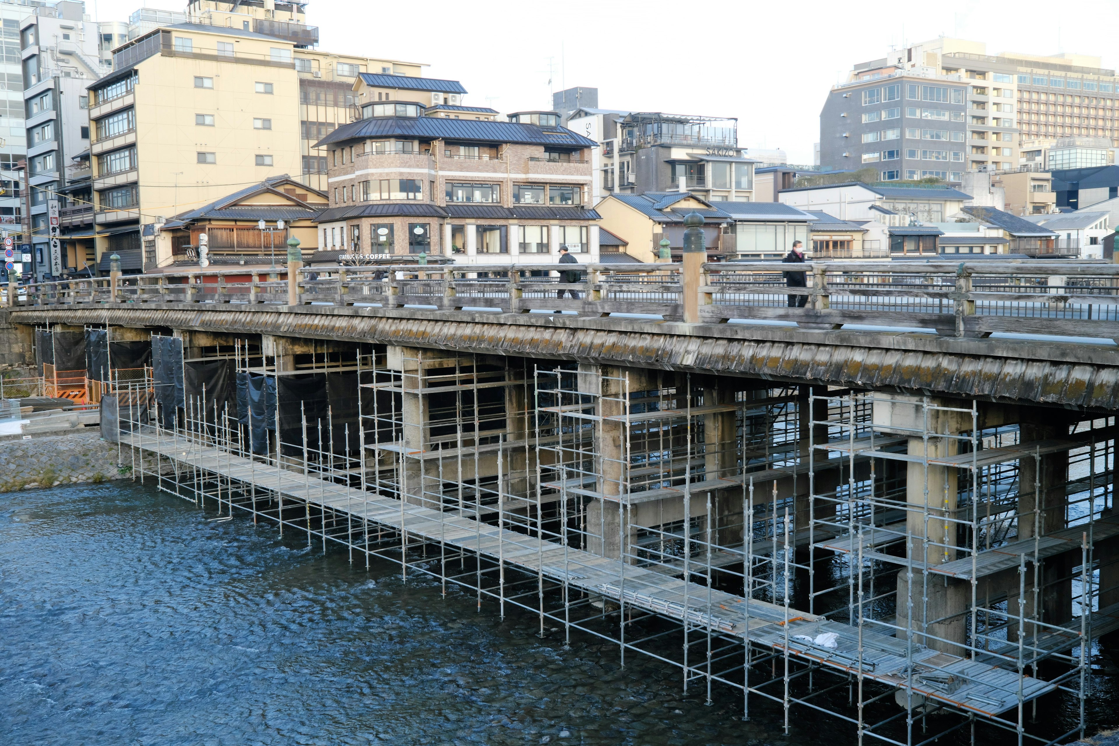 Site de construction d'un pont sur une rivière avec échafaudage visible