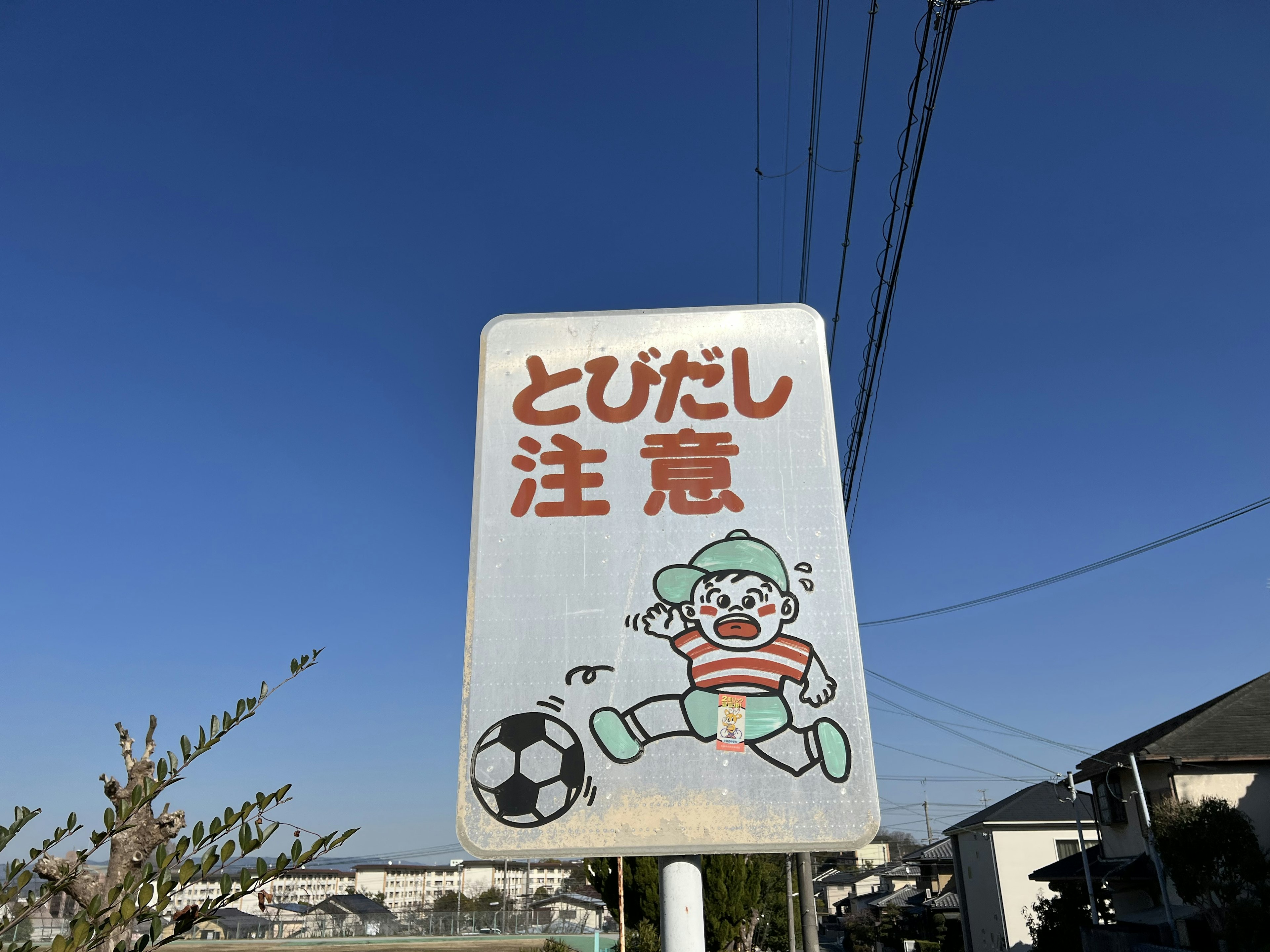 Warning sign featuring a child with a soccer ball illustration