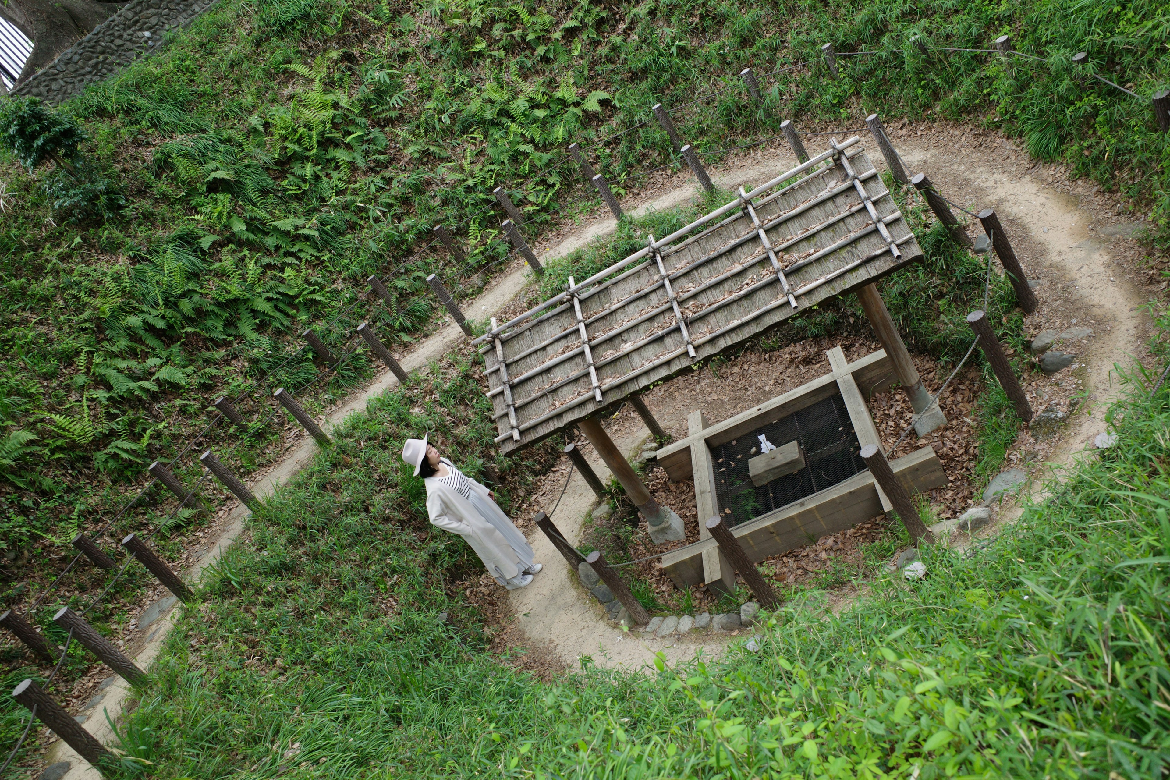 A scenic view of an old burial site surrounded by greenery and a wooden shelter