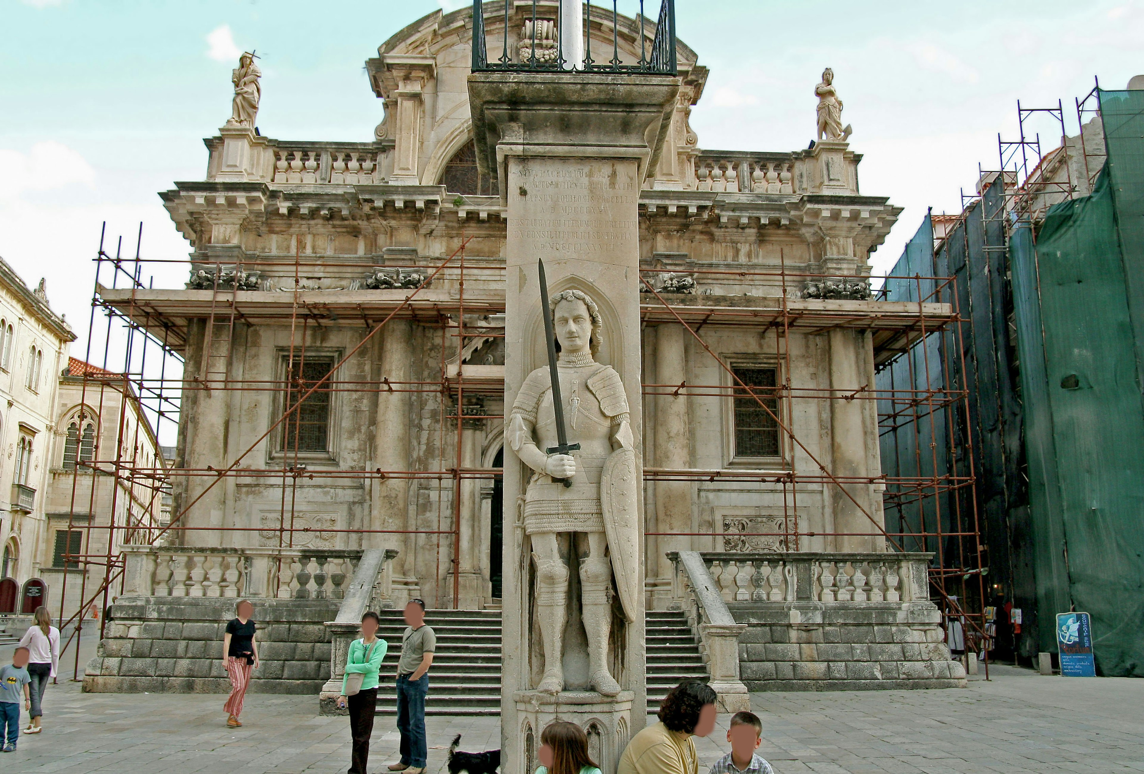 Statua in pietra di un guerriero davanti a una vecchia chiesa in ristrutturazione