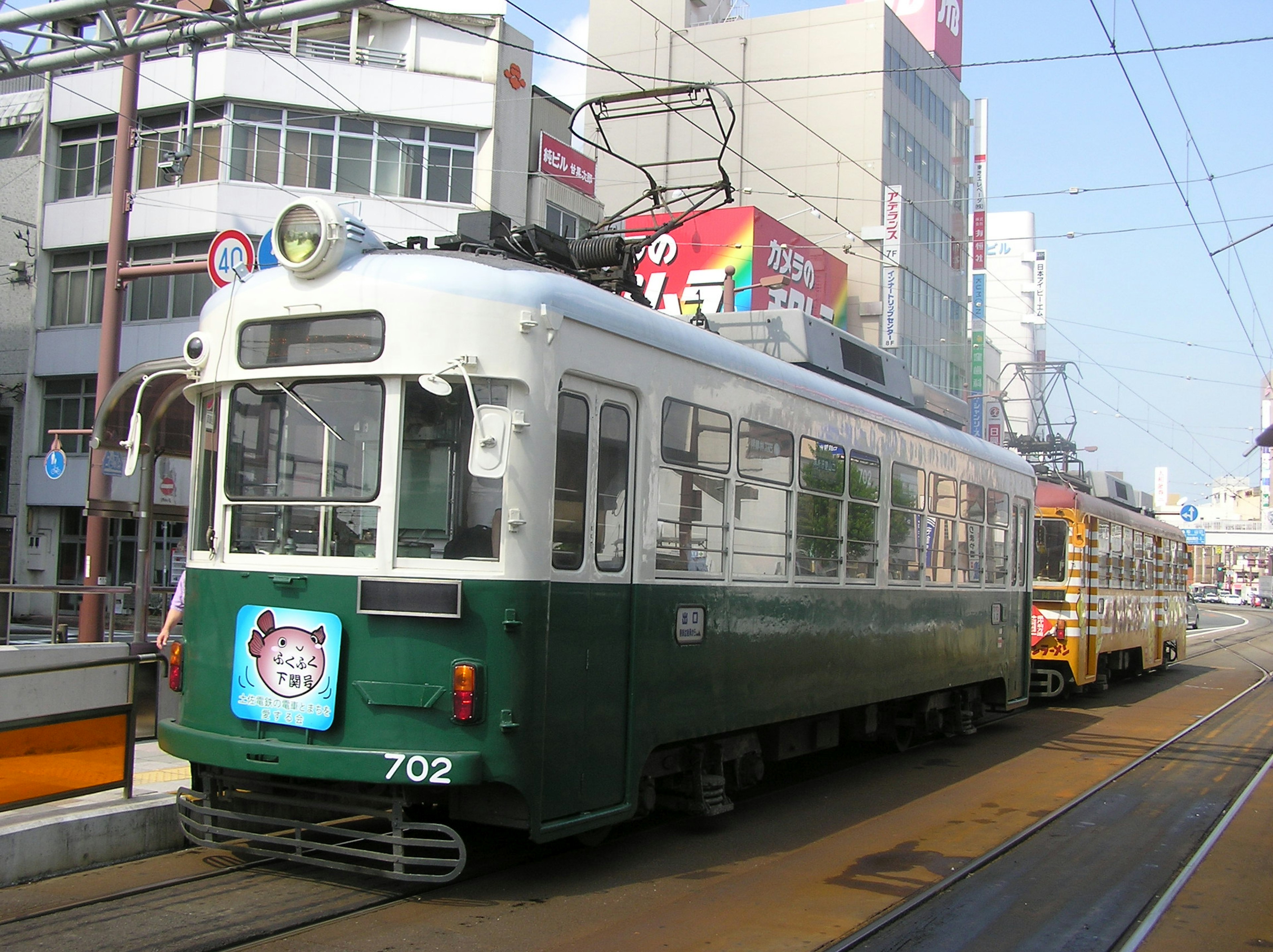 Green tram 702 parked in a city setting