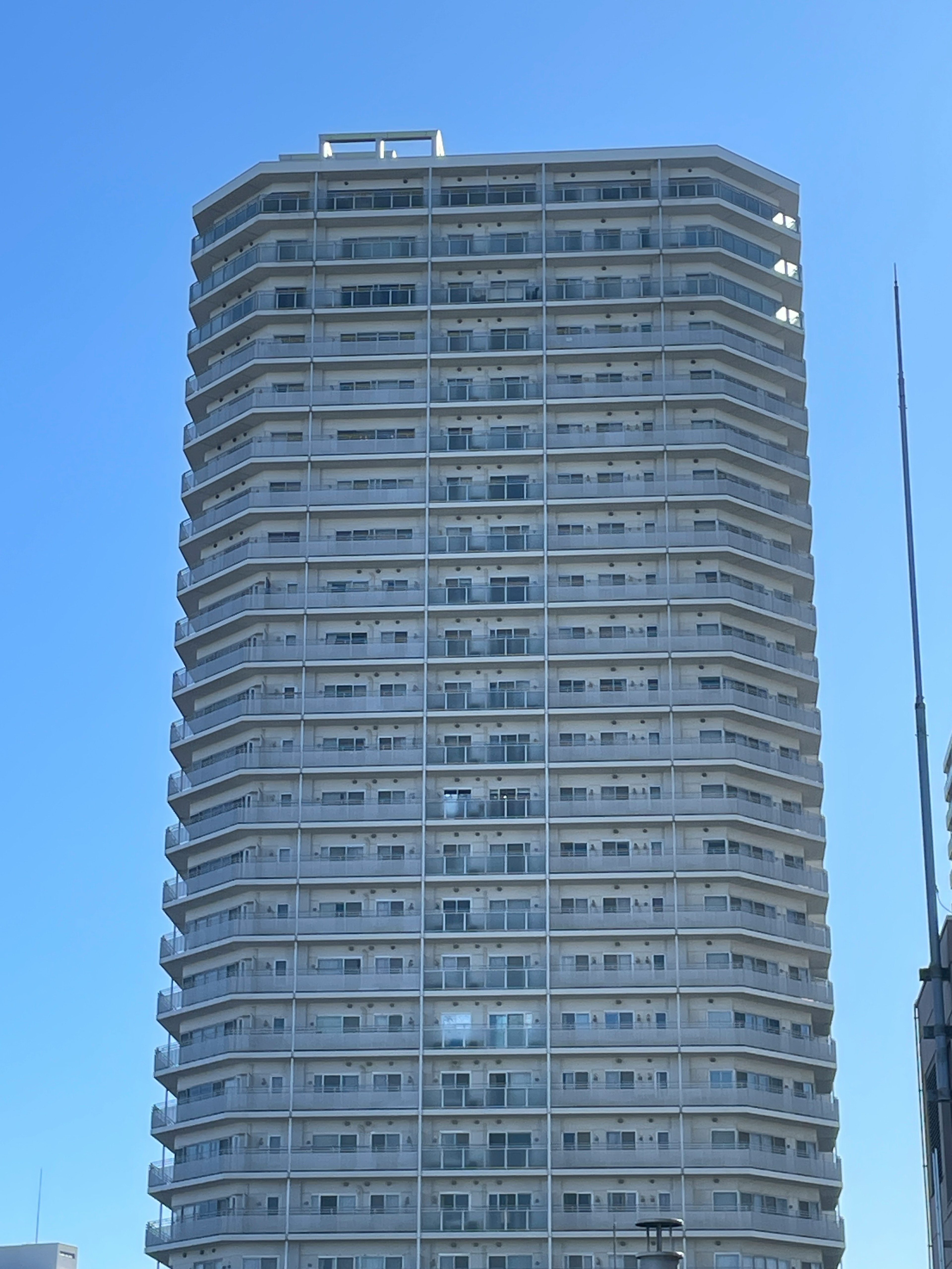 Gambar gedung pencakar langit menampilkan fasad putih dengan banyak jendela